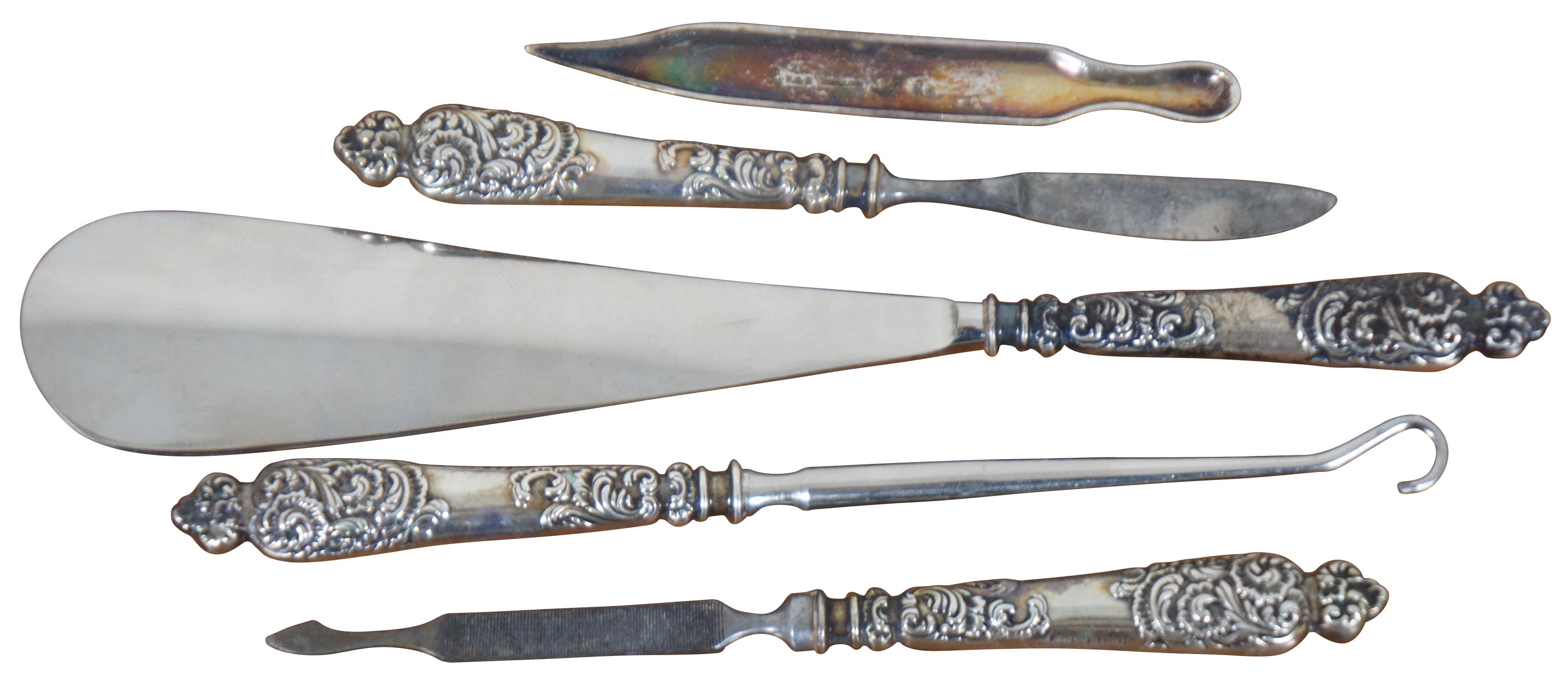 Early 20th century five piece vanity grooming set by Theodore W. Foster and Bros with art nouveau sterling silver handles, engraved with an M. Set includes a shoe horn, nail file, button hook, corn knife, and cuticle pusher. “Providence, RI -