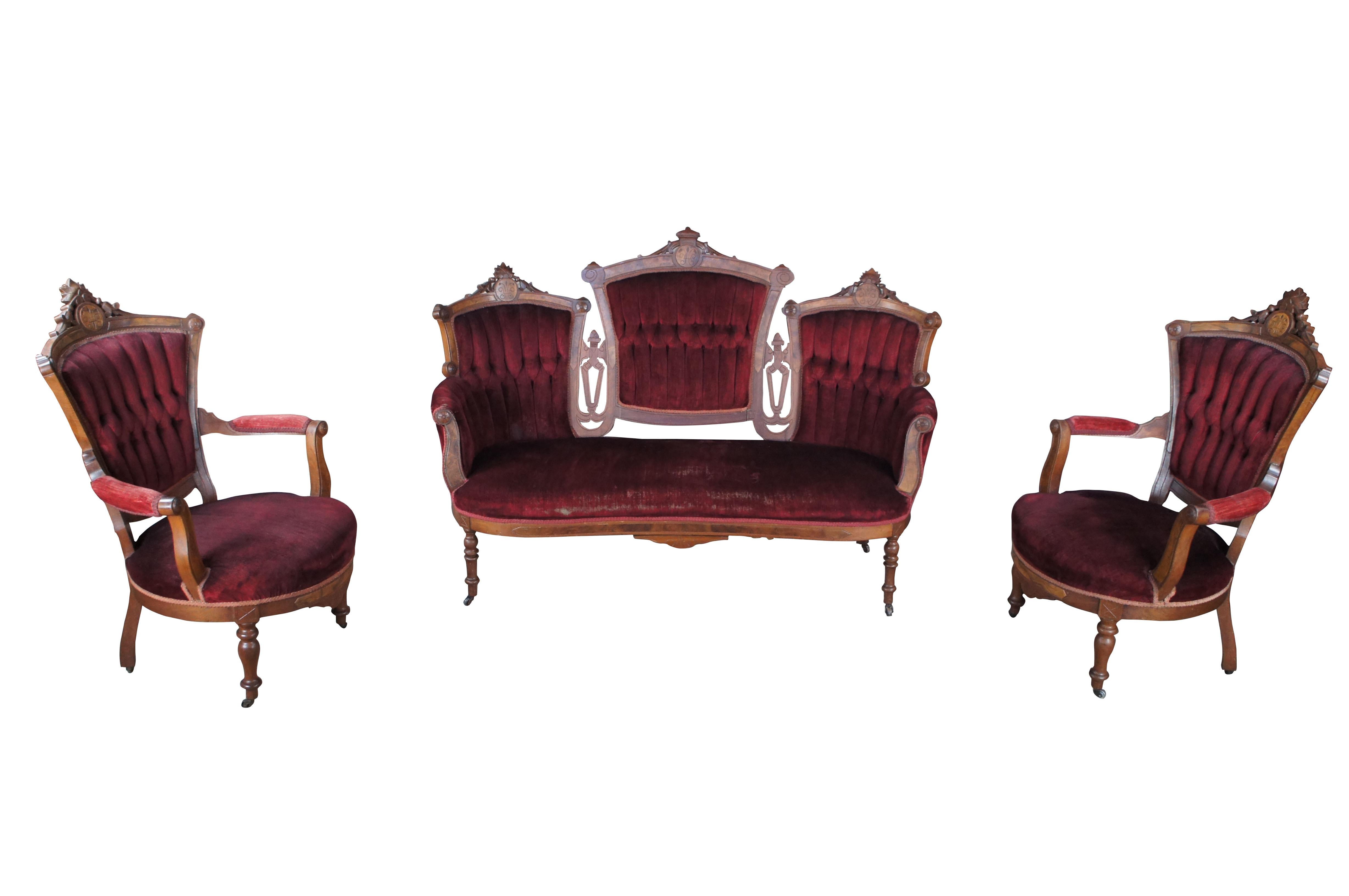 Antique Victorian parlor suite.  Made of walnut featuring Eastlake styling with carved reticulated floral crowns and tufted velvet upholstery supported by turned legs on castors.  Set includes settee bench seat / loveseat, two armchairs with padded