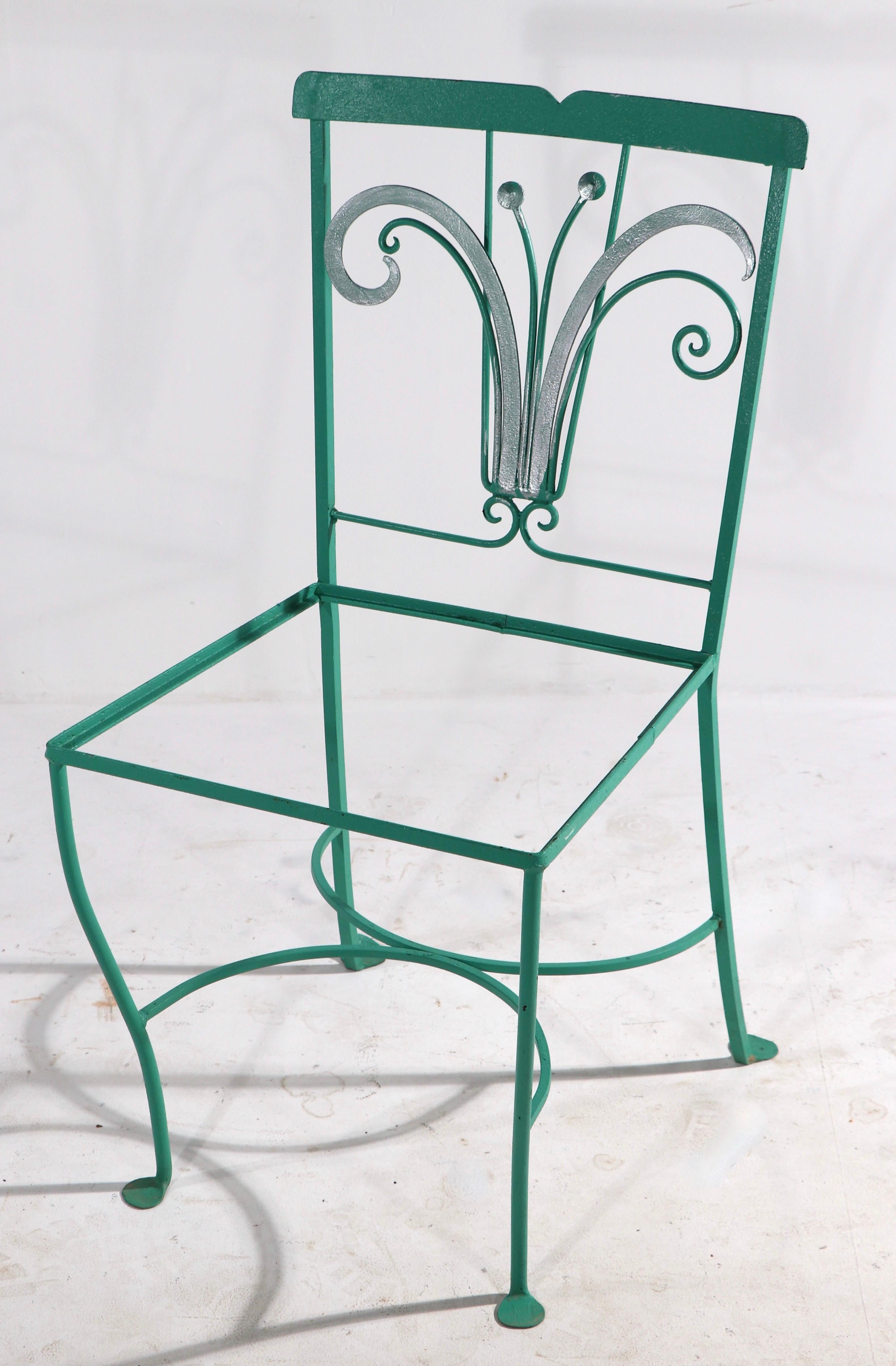 Highly styled Art Deco patio, garden, sunroom dinette set, having four side chairs, and the dining table. The set features an exuberant Deco stylized plant motif, currently in later green paint with silver highlights. 
 Dimensions for chairs: