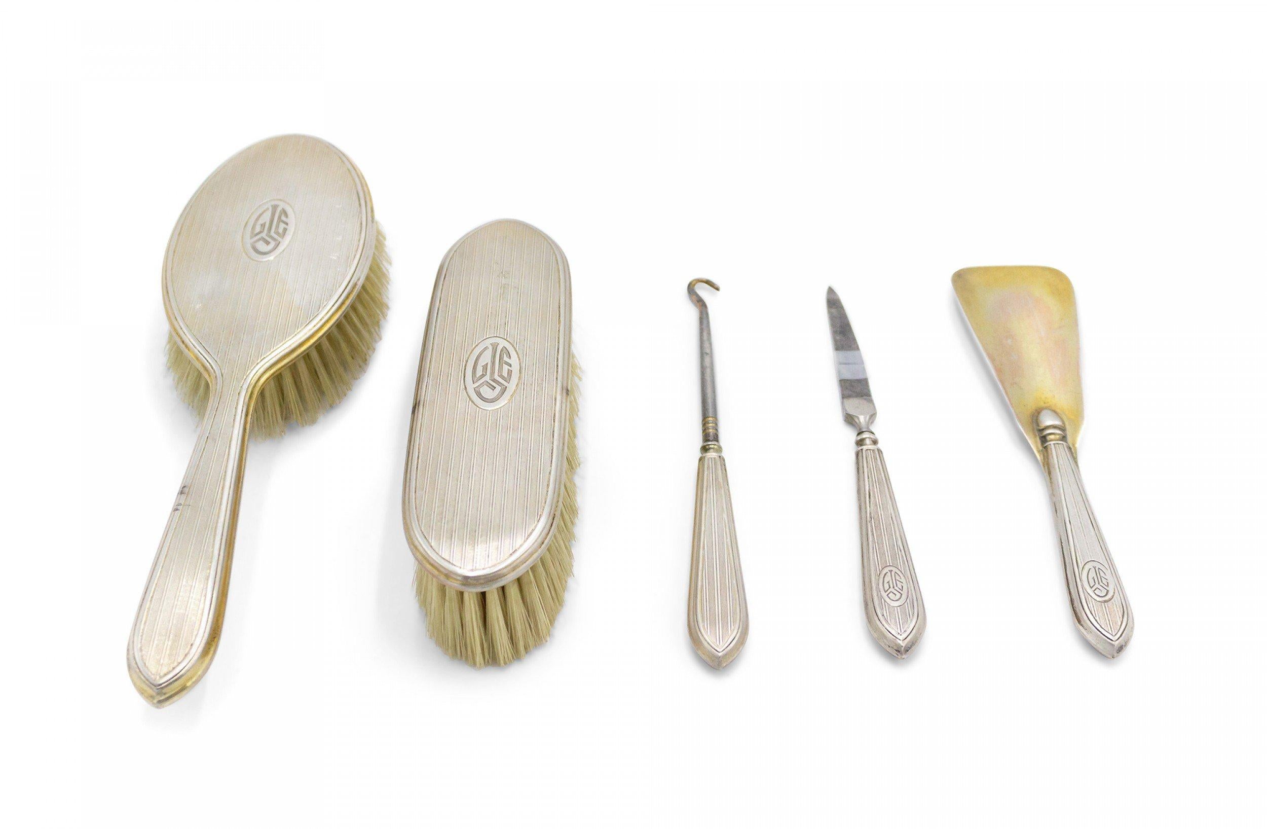 Ensemble de 5 brosses en argent de style victorien américain avec design cannelé et initiales GJE gravées dans un médaillon ovale (2 brosses, corne à chaussures, lime, crochet de corset) (PRIX POUR L'ENSEMBLE)

Condition : (S'il vous plaît noter