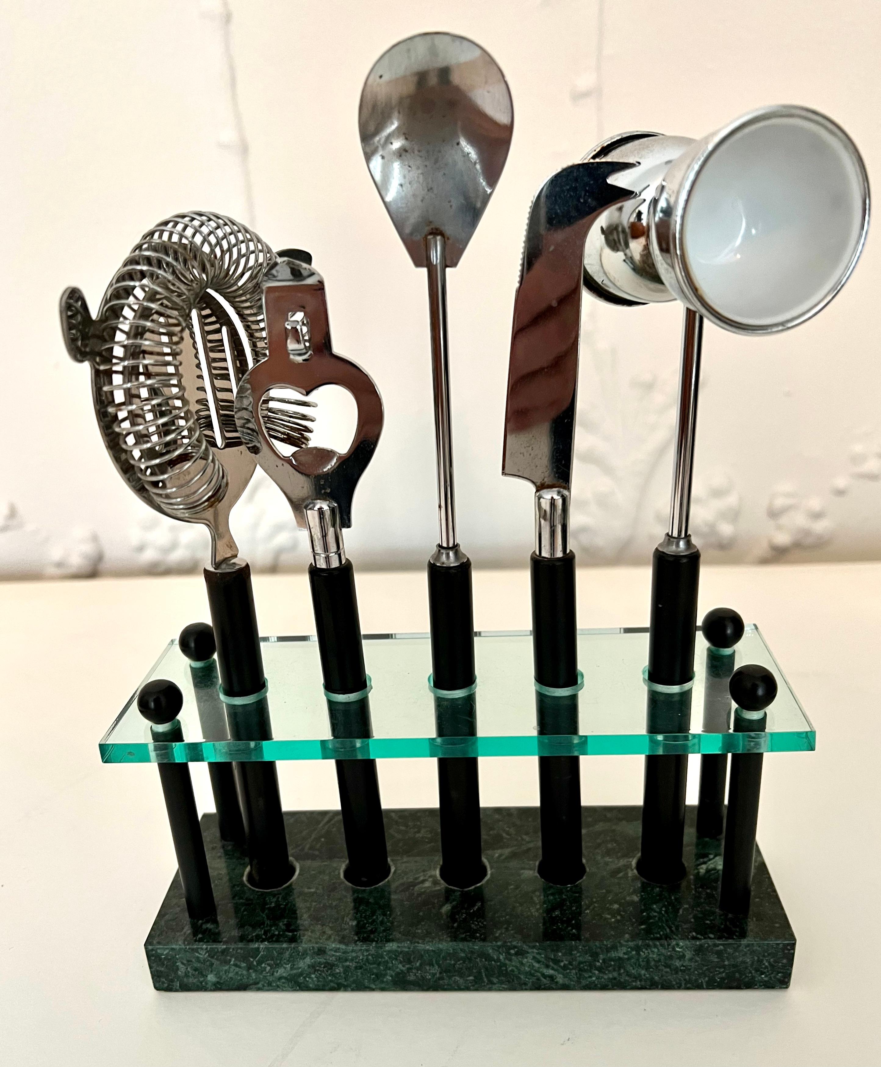 For the Bartender that wants all their accessories at an easy reach - a marble and glass stand that holds a strainer, can/bottle opener, two-sized jigger, spoon and bar knife.

The set is concise, organized and instead of being placed in a