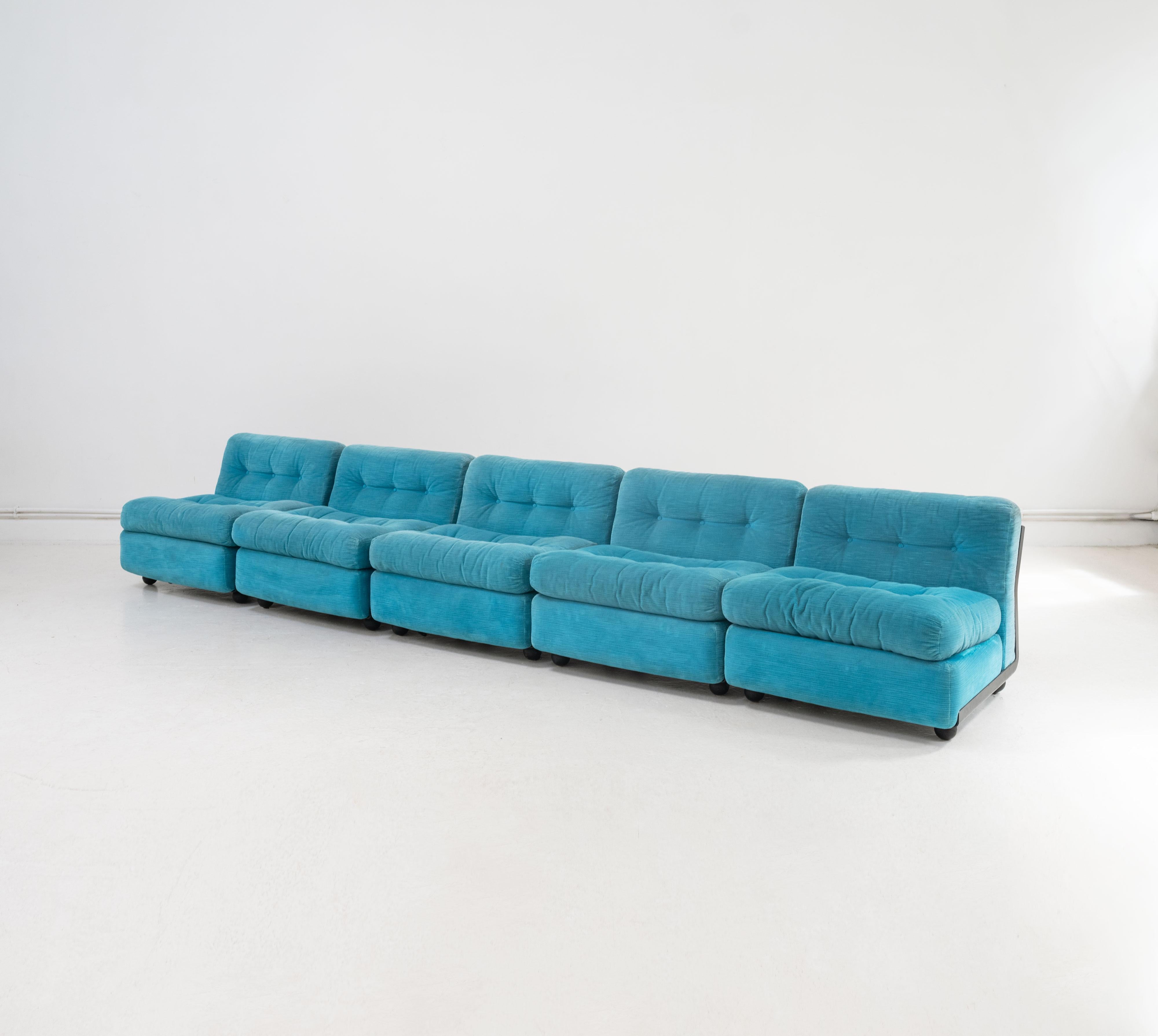 A 5 piece 'Amanta' sofa designed by Mario Bellini and manufactured by B&B Italia in the 1980's. Each module is composed from a black enamelled fibrelite shell with rubber feet upon which seat 3 upholstered cushions in an aquamarine corduroy. The