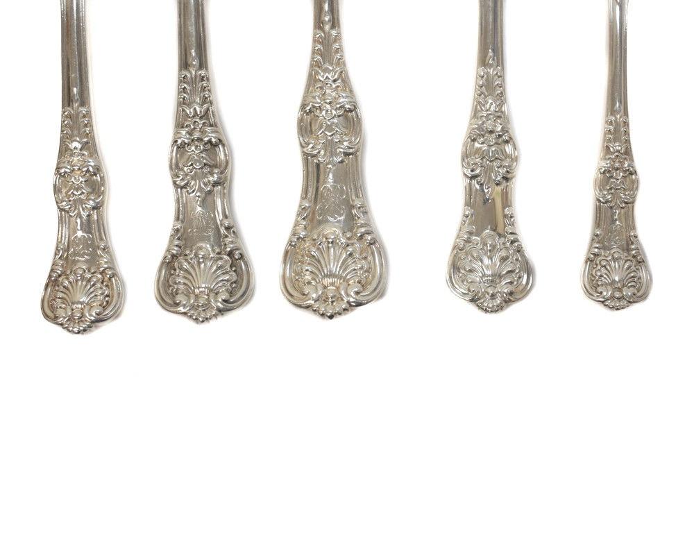 An exquisite 5-piece service for 12 Tiffany & Co. sterling silver flatware in English King, Issued 1885. Hand chased foliate scroll accents with shell designs to the handle of the pieces. Tiffany Mark to the underside. Comes in its original Tiffany