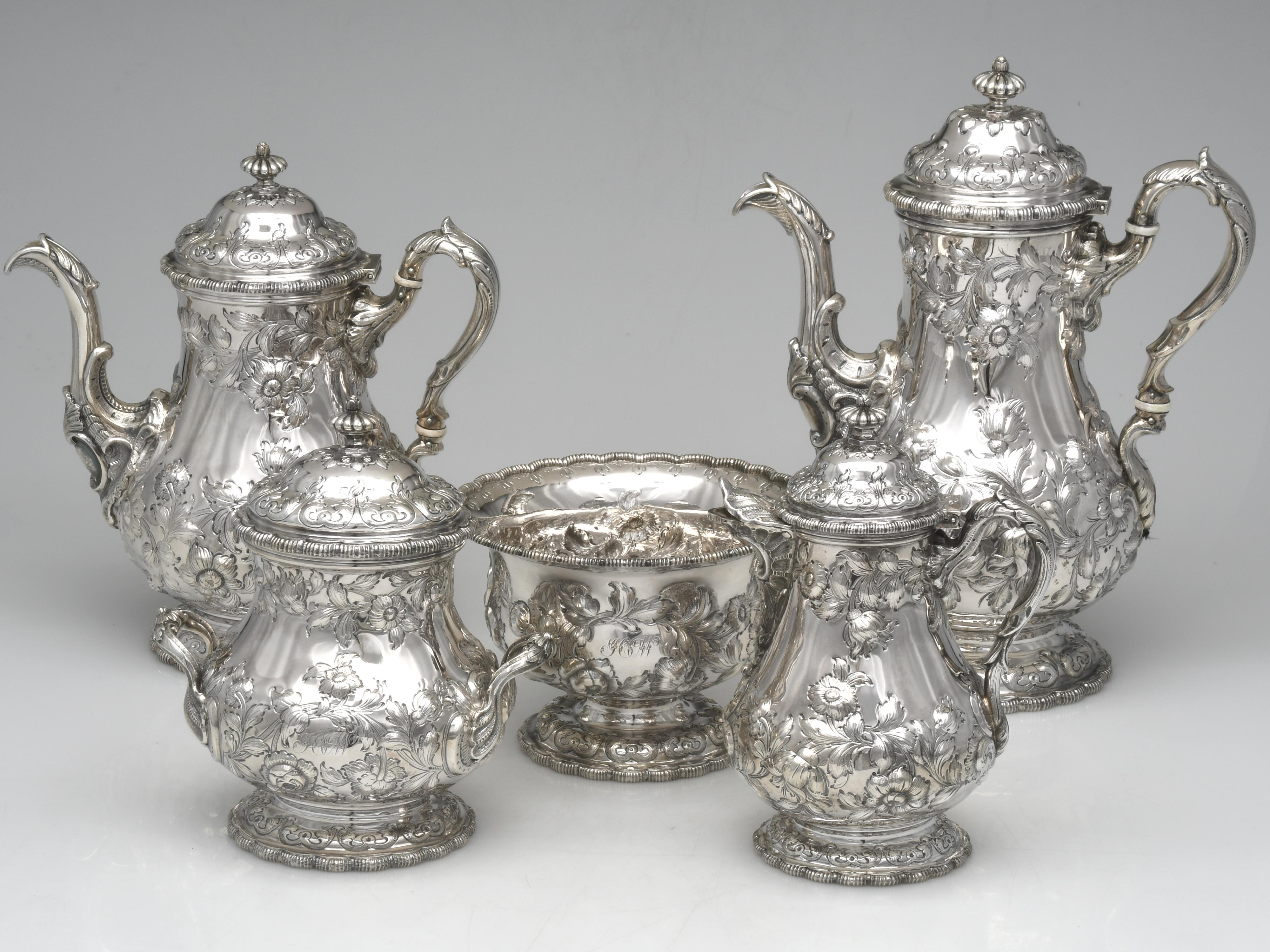 This ornate coin silver tea/coffee service is designed in the Rococo Revival style, which was especially popular in the mid to late 19th century. This set includes a coffee pot, tea pot, creamer, sugar and waste bowl. Produced by Tiffany & Co. circa