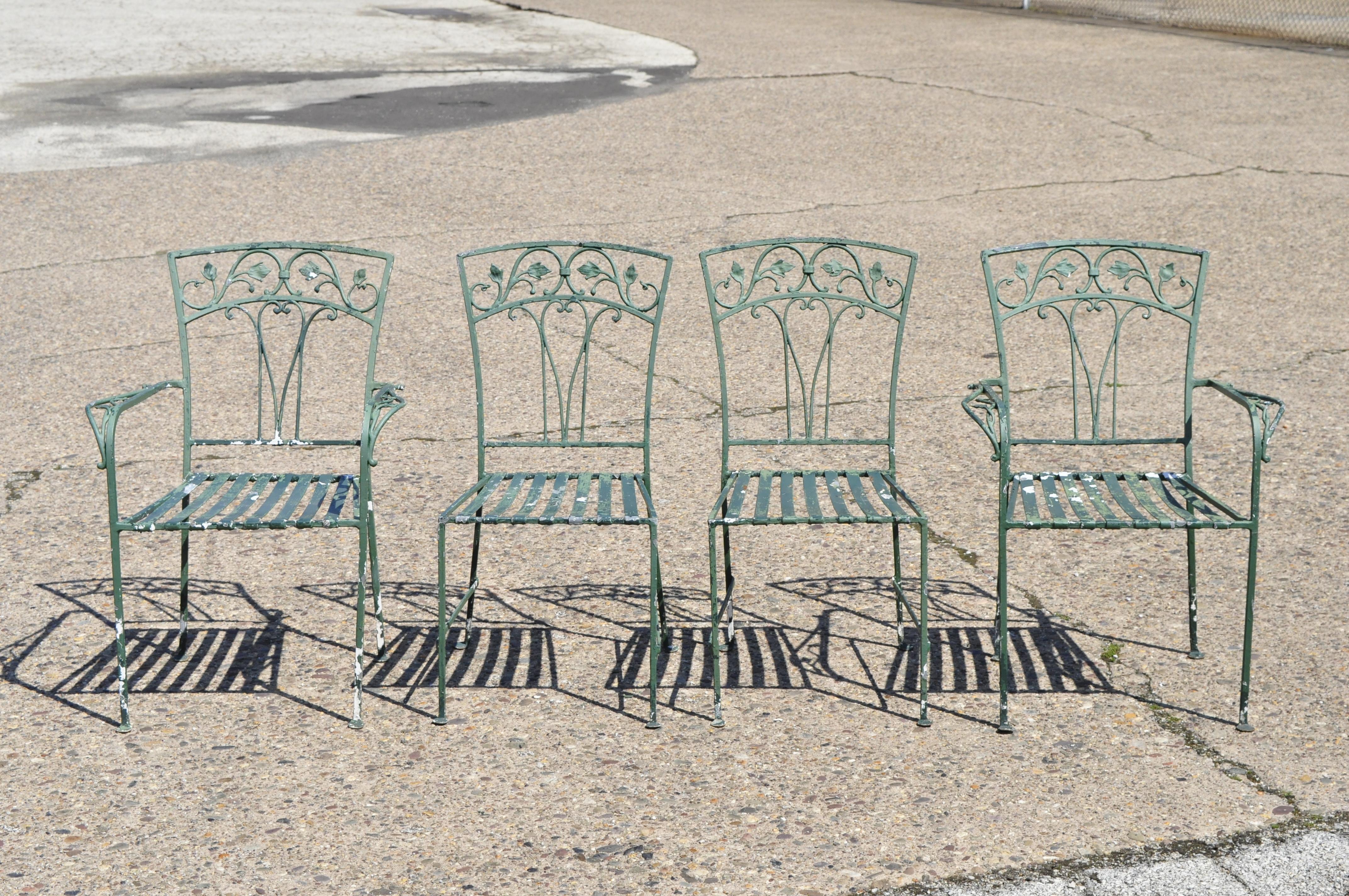 5-piece vintage Salterini leaf and vine patio garden dining set oval table. Listing includes (2) armchair, (2) side chairs, large oval glass top dining table, leaf and vine design, metal strap seats. Mid-20th century. Measurements:

Measures:
