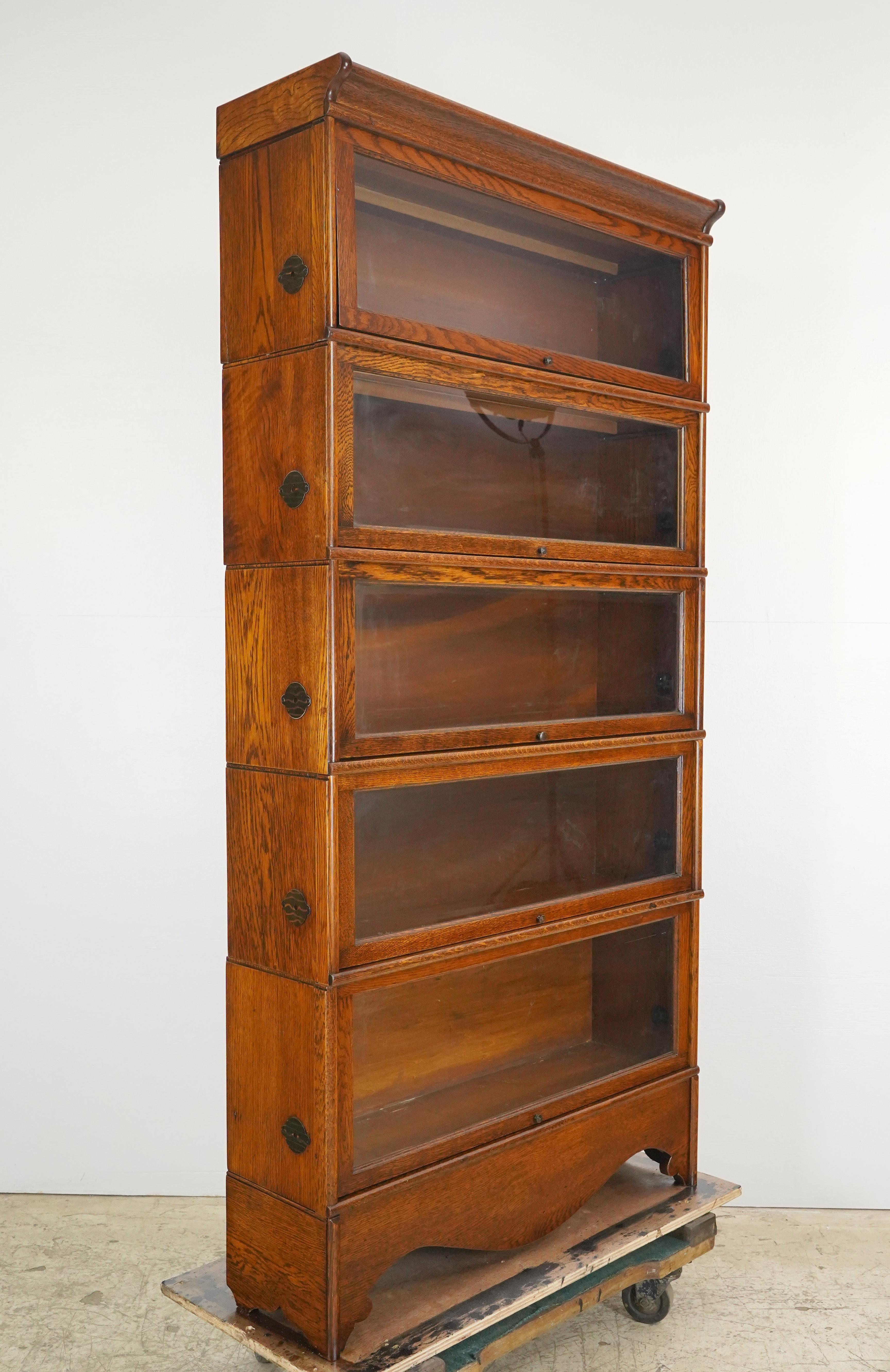 Grande libreria barrister a cinque sezioni in Oak con pomelli originali in ottone. Le librerie da barrister sono state originariamente progettate per i barrister o gli avvocati per conservare le loro biblioteche. Realizzata da Rockwell-Wabash,