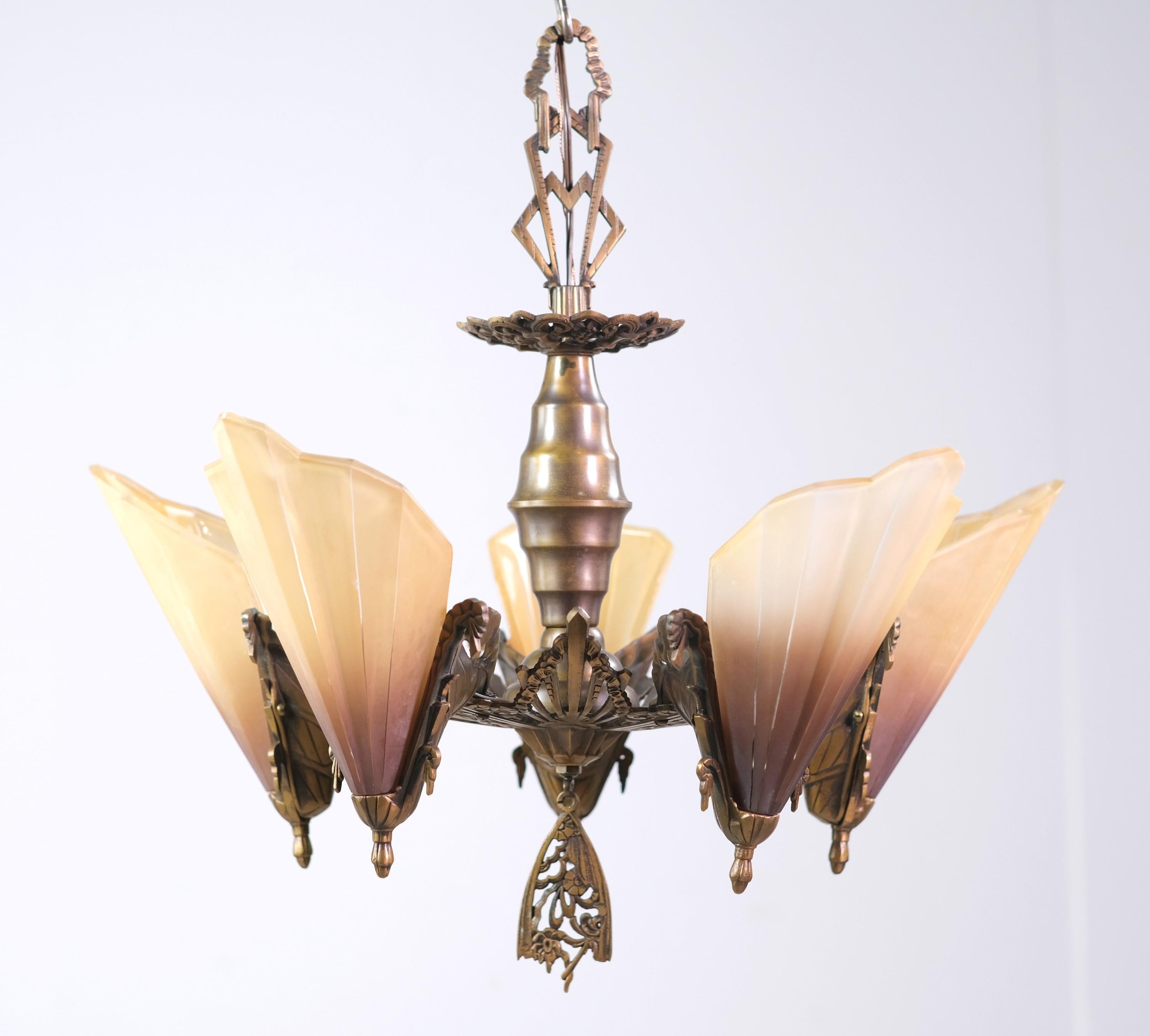 Art Deco 5 light cast bronze chandelier with slip shades. Ornate details with swag, ribbon, and floral motifs. Cleaned and restored. There is minor wear in the paint. Please see the photos.Please note, this item is located in one of our NYC