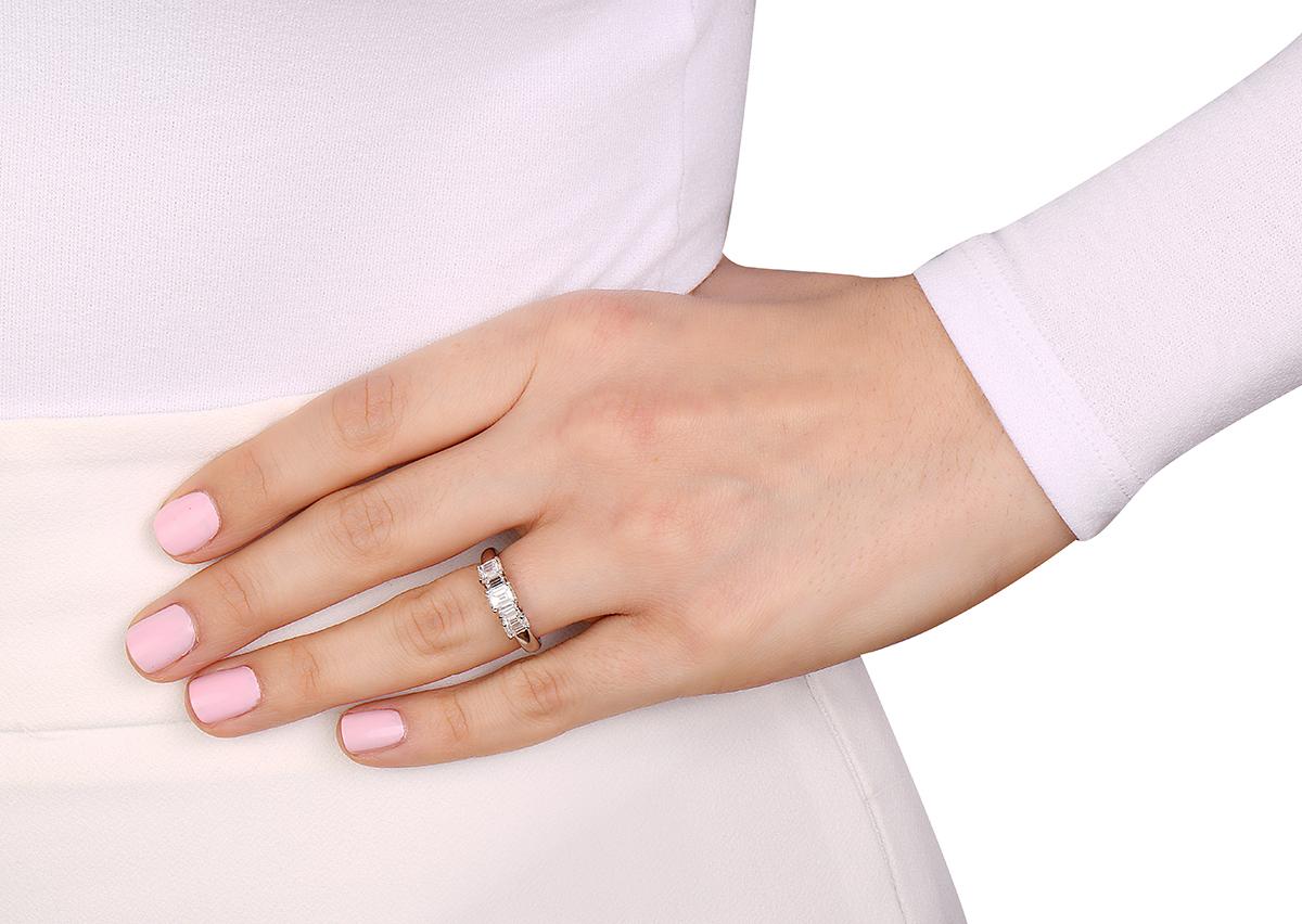 Este anillo de compromiso tiene 3 diamantes talla esmeralda de 1,37 quilates y 2 diamantes talla baguette de 0,16 quilates con graduación H-I, SI1 100% limpios de ojos. Talla 6.5. Fabricado en Italia. 

Se puede cambiar el tamaño si se solicita.