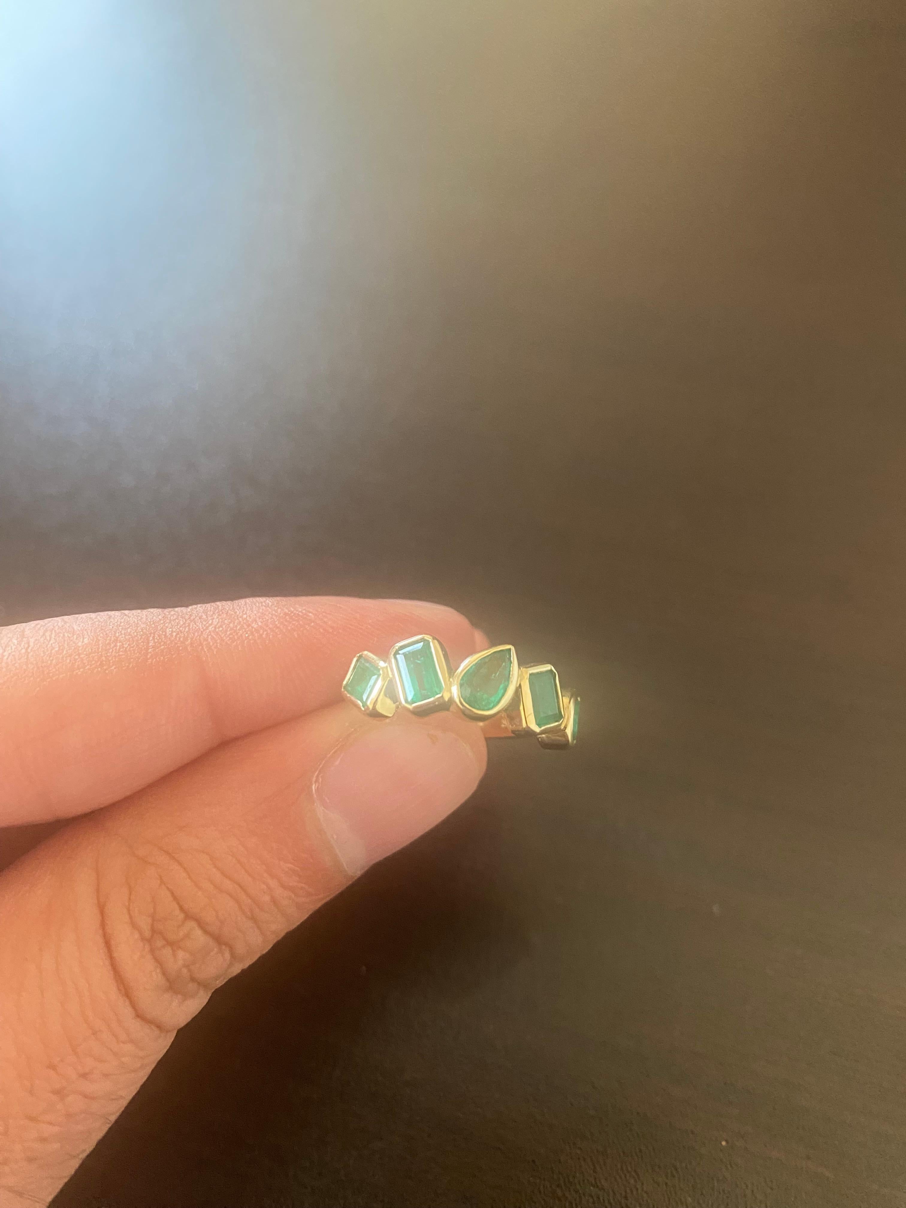 5 stone Green Emerald band set in 14K yellow gold. The ring is set with Emerald, princess, and pear shaped stones. Each stone weighs approximately 0.40-0.45 carats. The total weight is 2.14. The ring is a size 6.5 and can be sized.