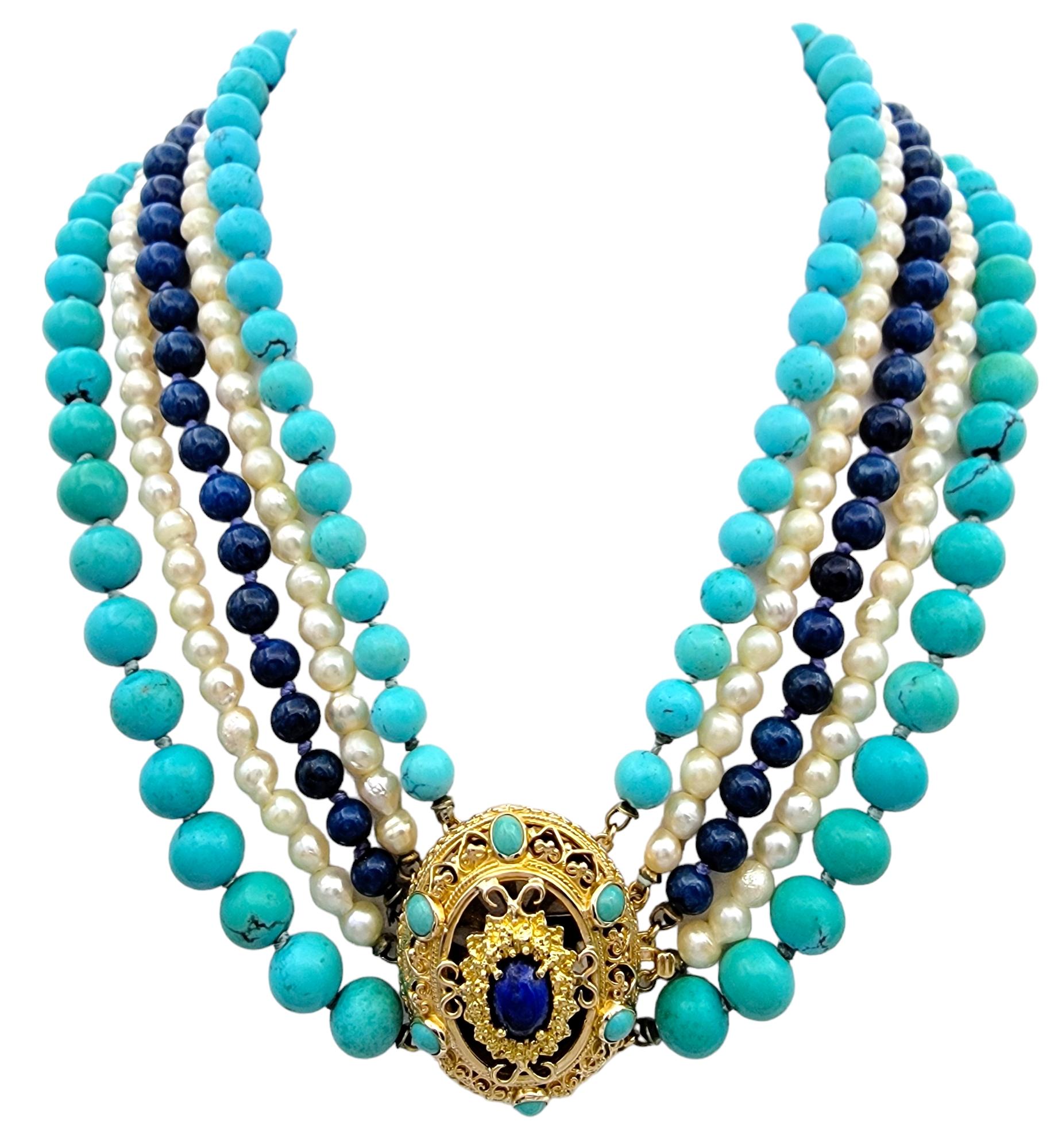 Te presentamos este magnífico collar de cinco vueltas, una auténtica obra maestra de arte y elegancia. Esta impresionante pieza combina la belleza de las perlas, la turquesa, el lapislázuli y el jaspe azul teñido, creando una armoniosa mezcla de