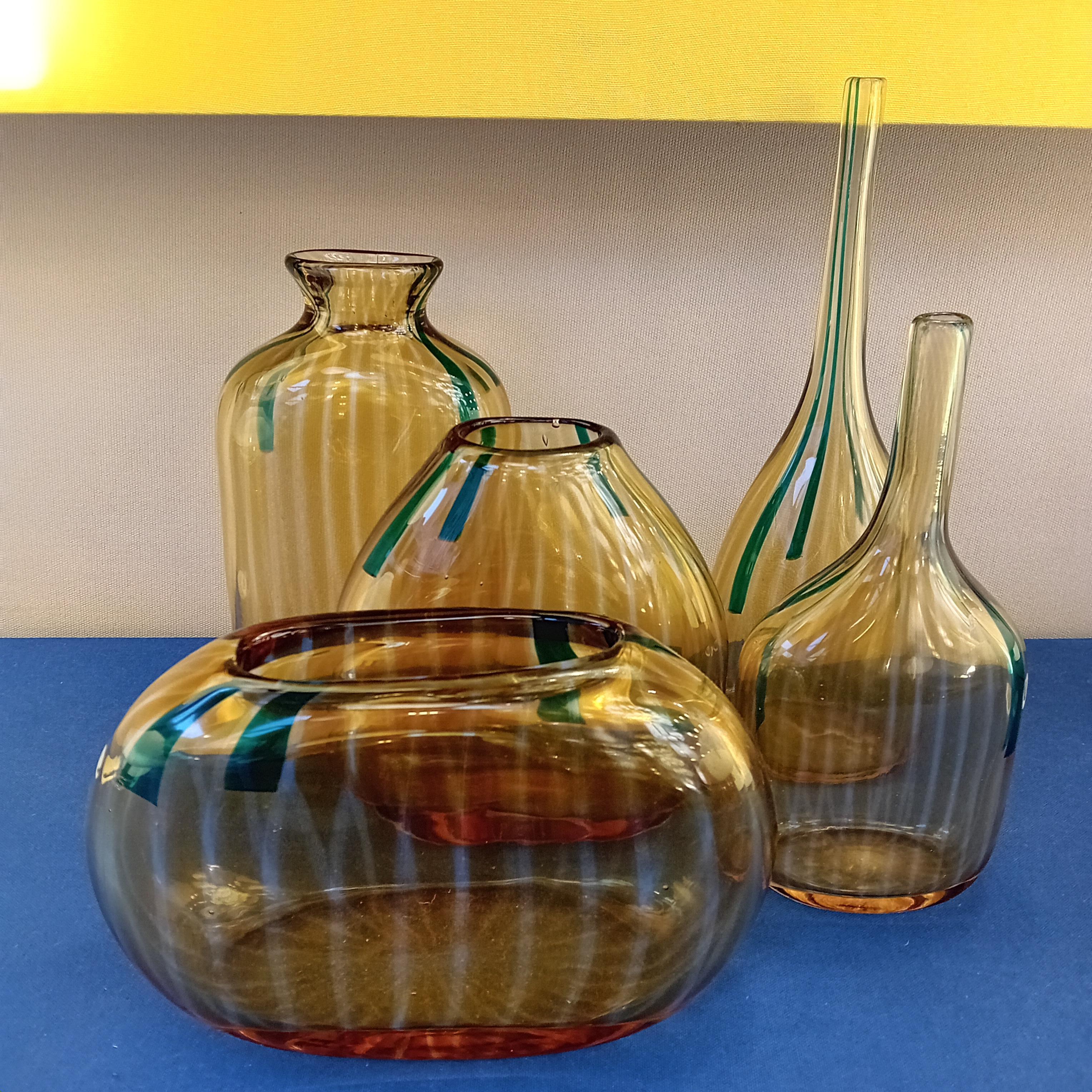 Cet ensemble de cinq vases a été conçu par Sergio Asti en 1963 et présenté à la XXXIIe Biennale de Venise. La série s'appelle Calle et se compose de vases dentelés faits de cannes de verre fondu.
Couleur : orange, translucide et vert antique

Biblio