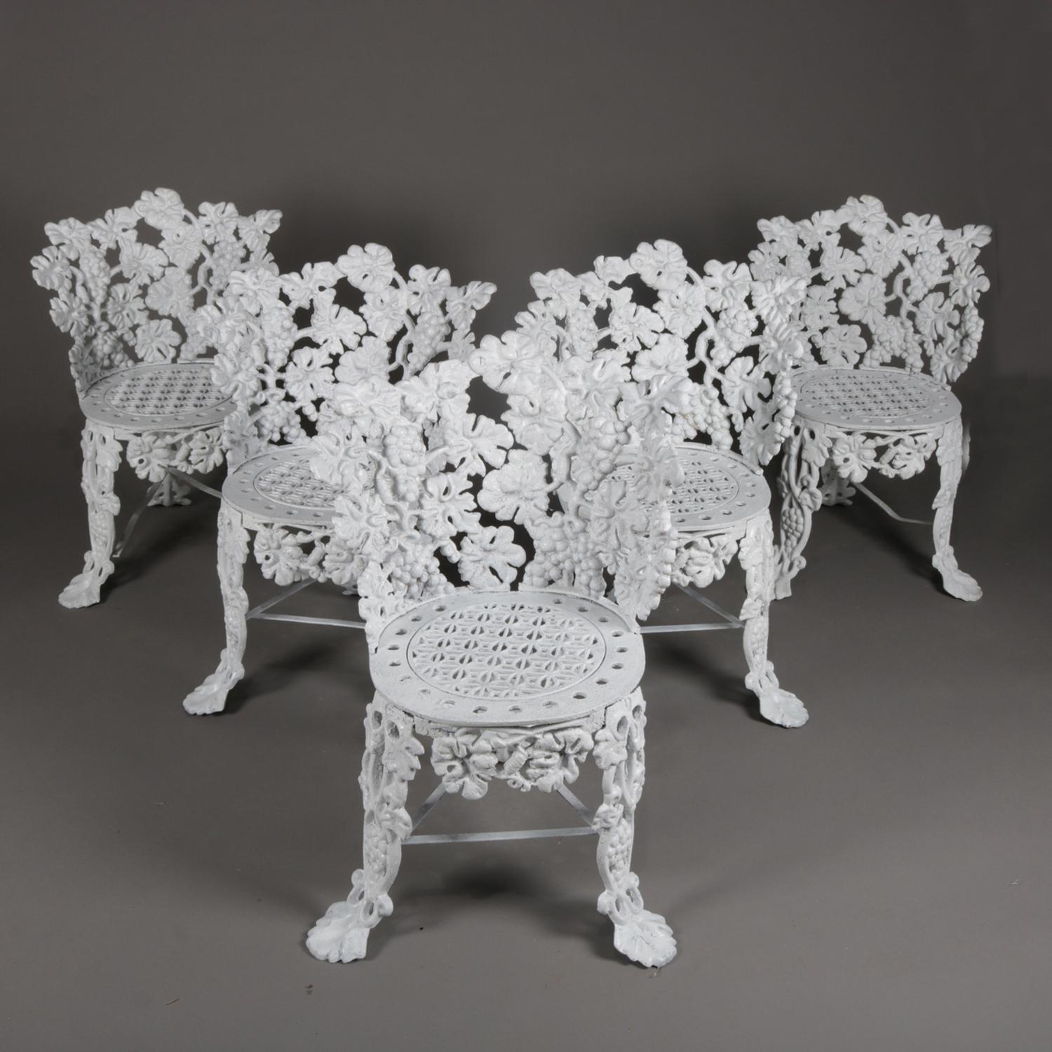 Set of 5 Victorian reticulated garden chairs features cast iron construction in grape and leaf pattern and seated on cabriole legs terminating in stylized paw feet and painted white, 20th century

Measures: 29