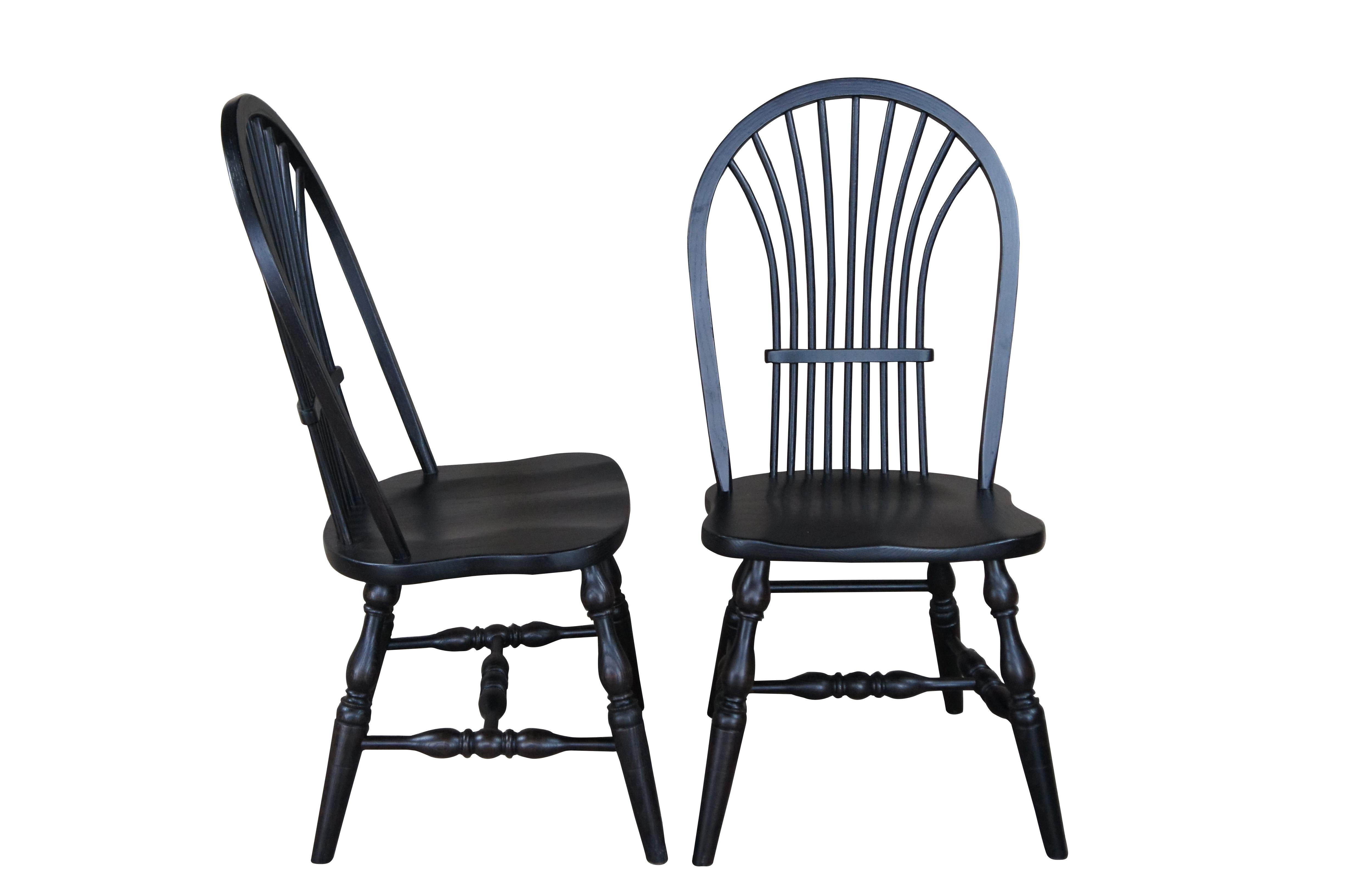 A set of six Windsor farmhouse dining chairs. Made of oak featuring black painted finish with a bentwood slatted sheaf back, turned legs and formed seat.

20