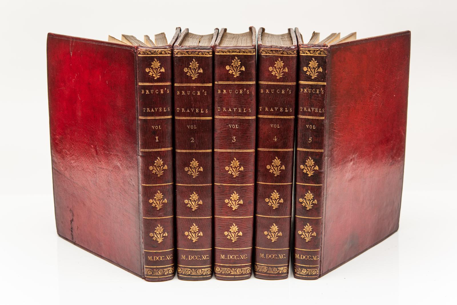 5 Vol. James Bruce Kinnaird Esq. F. R. S., Viajes para descubrir la fuente del Nilo. Primera edición. Ilustrado con 3 grandes mapas desplegables y 58 láminas. Encuadernado en becerro rojo oscuro. Empapelado jaspeado. Bordes interiores de cubierta
