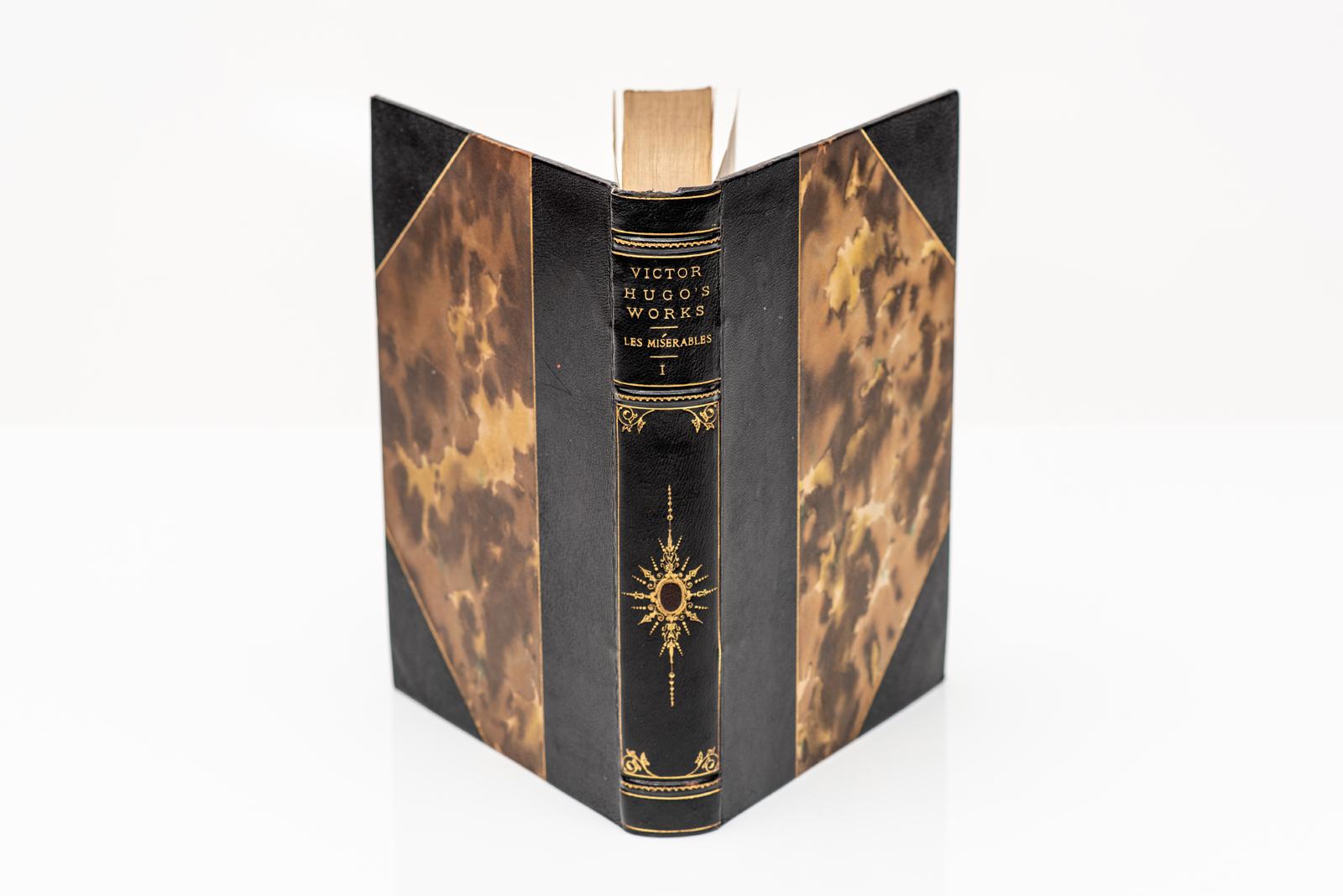 5 Volumes. Victor Hugo, Les Misérables in Five Volumes. Centenary Edition. Bound in 3/4 black morocco and marbled boards. The covers and raised band spine are gilt tooled with ornate detail on the spine. Top edge is gilt. Marbled endpapers. Limited