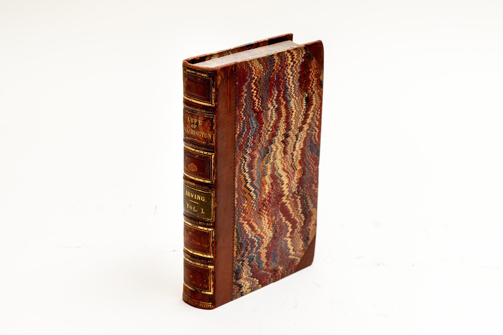 5 Volumes. Washington Irving, Life of George Washington. Bound in 3/4 brown calf and marbled boards with the raised band spines gilt-tooled with tan and green morocco labels. All of the edges are marbled with marbled endpapers. New York: G.P. Putnam