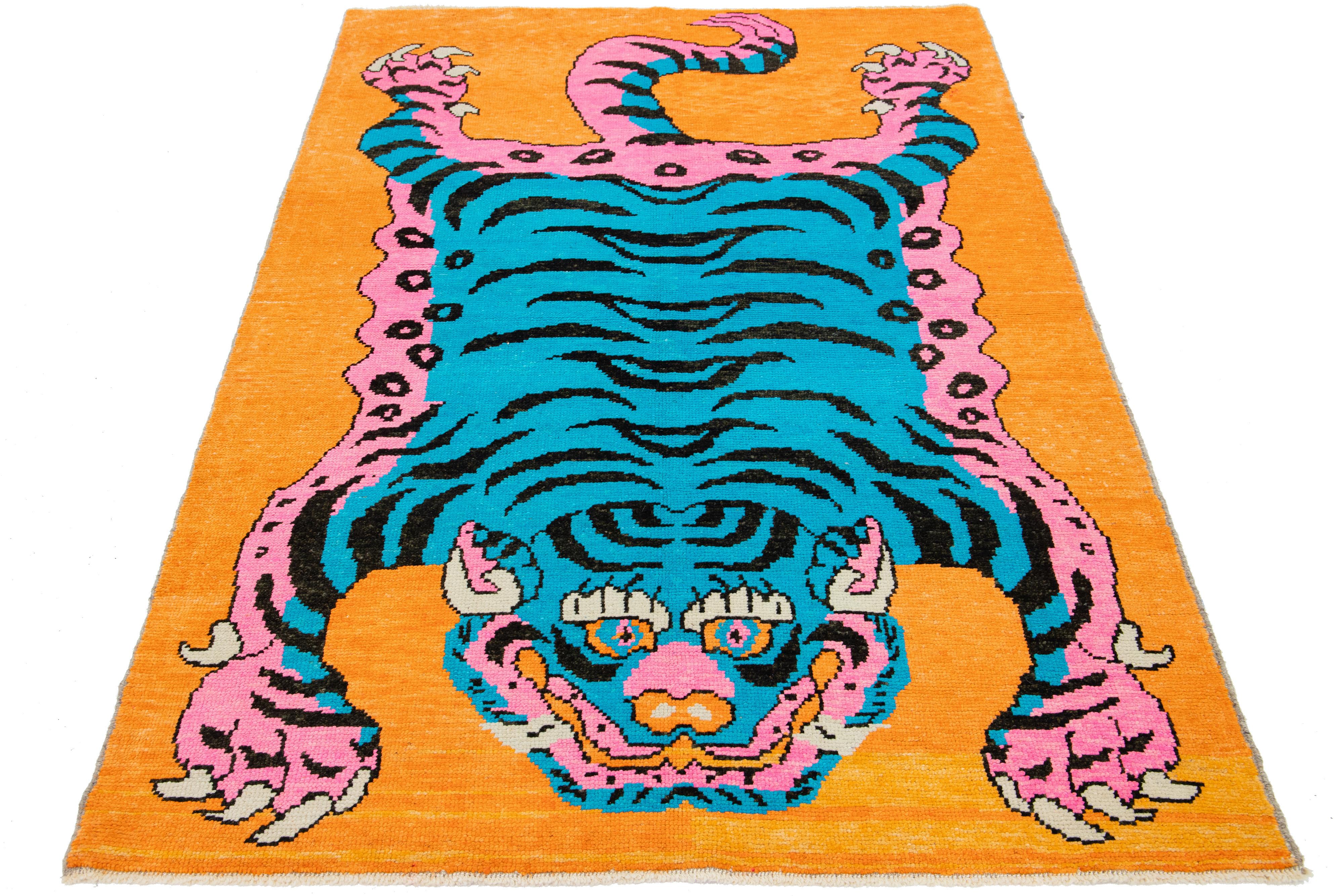 This is a beautiful handmade Turkish Art Deco wool rug with an orange field and blue, pink, and purple accent colors in a gorgeous tiger pictorial design. 

This rug measures 5'4