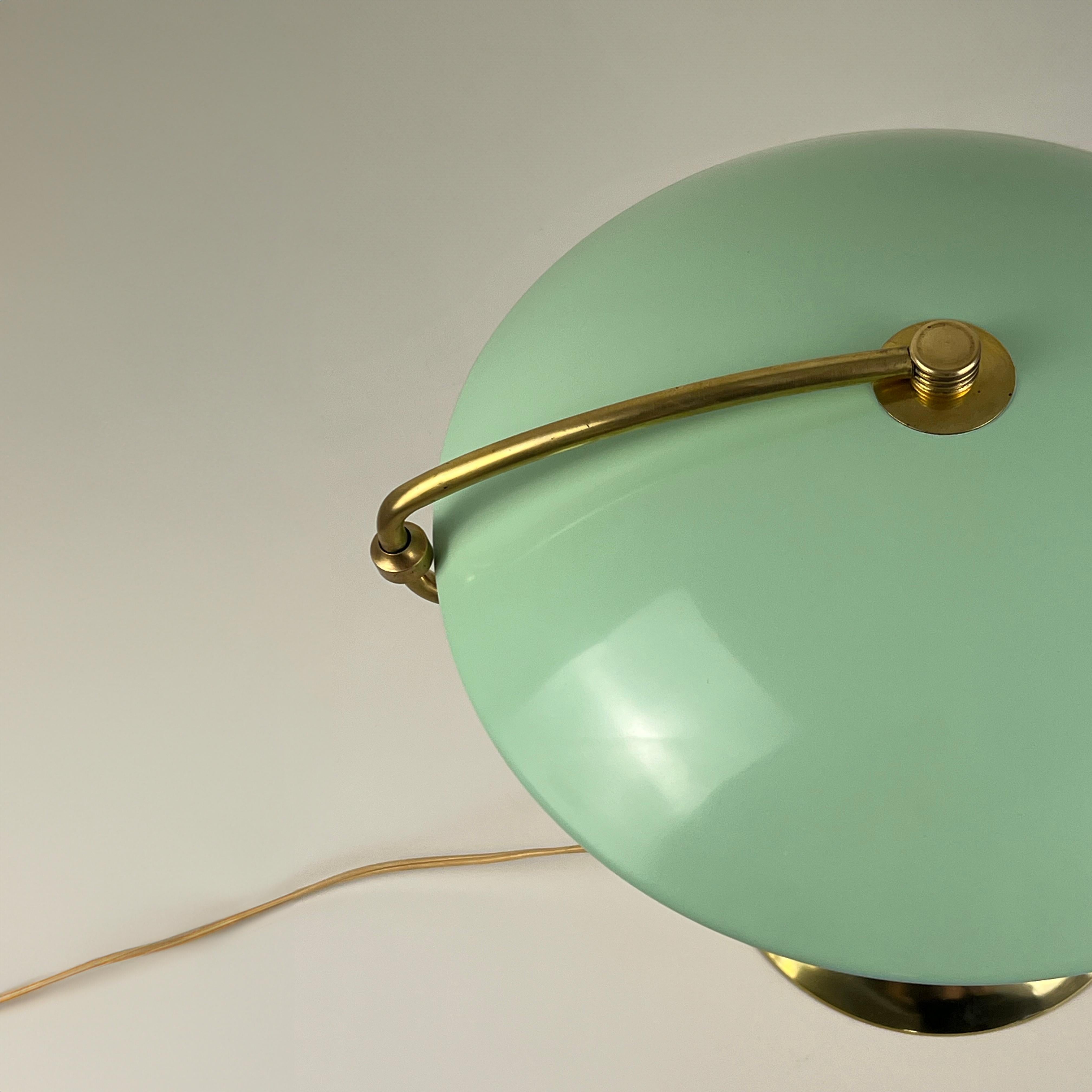 Extraordinaire lampe de table vintage en laiton des années 1950, dotée d'un bras pivotant et d'un charmant abat-jour vert menthe. Cette pièce intemporelle allie un design élégant à des détails vintage irrésistibles. 

L'abat-jour arrondi tourne