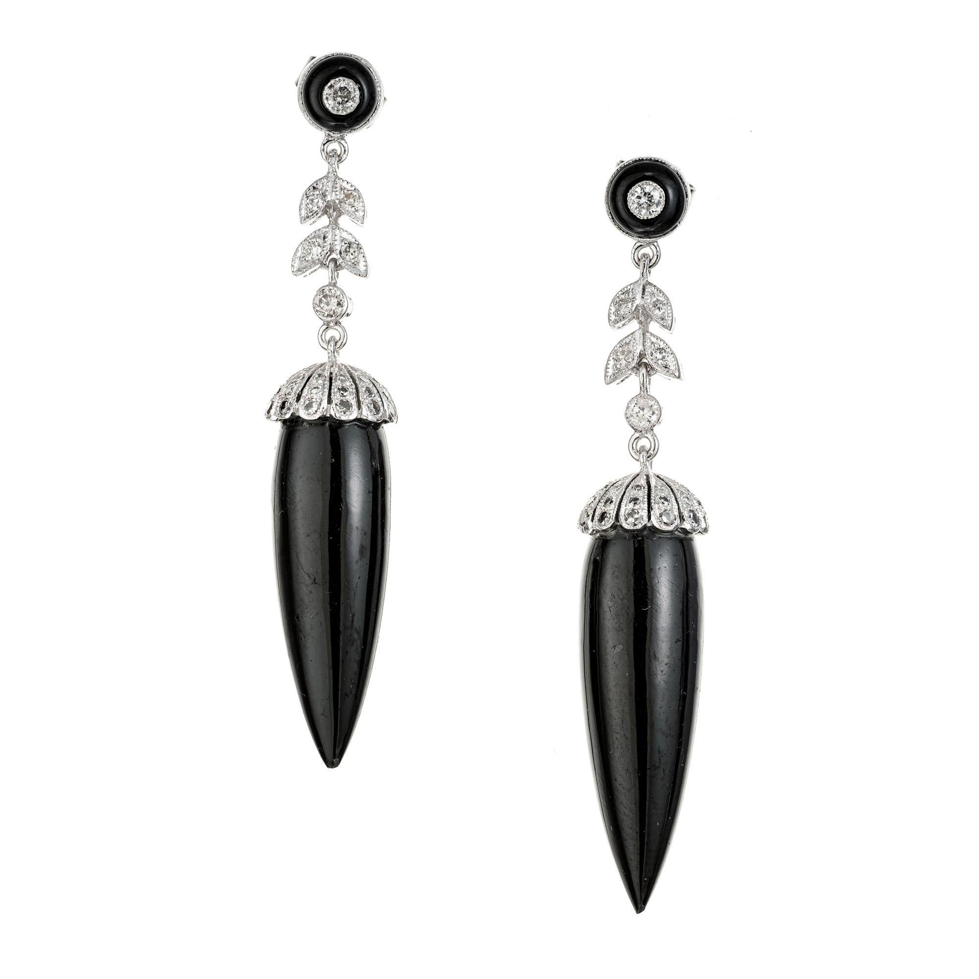 Roaring 1920's Art Deco onyx and diamond dangle earrings. 2 onyx dangles with 84 round brilliant cut accent diamonds and 2 onyx halos in 14k white gold.

84 round brilliant diamonds, H-I I approx. .50cts
2 black onyx drops, 2.8mm x 8.5mm
2 black