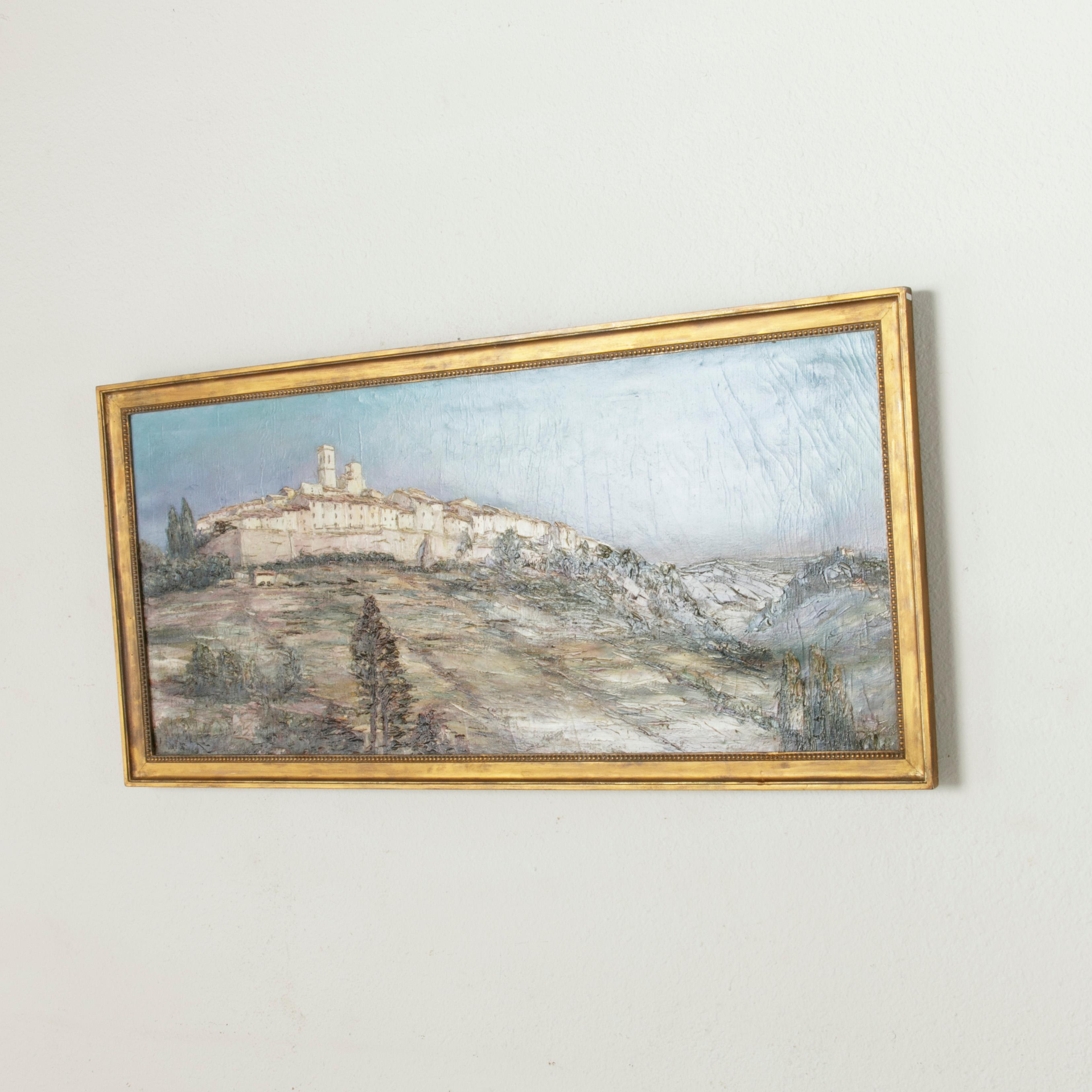 Measuring 50.5 inches wide, this large oil on canvas painting from the early 20th century features a panoramic view of the village of Saint-Paul de Vence in Southern France. Signed by the artist L. Lutz in the bottom left corner, this painting is