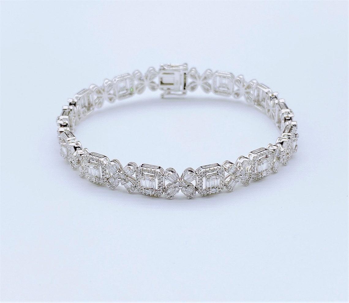 The Following Item we are offering is a Rare 18KT Gold Diamond Bracelet. Bracelet is comprised of Finely Set Magnificent Gorgeous Glittering Baguette Cut Diamonds with Floral Diamond Motifs set in 18KT White Gold and Framed with Round Diamonds!!!