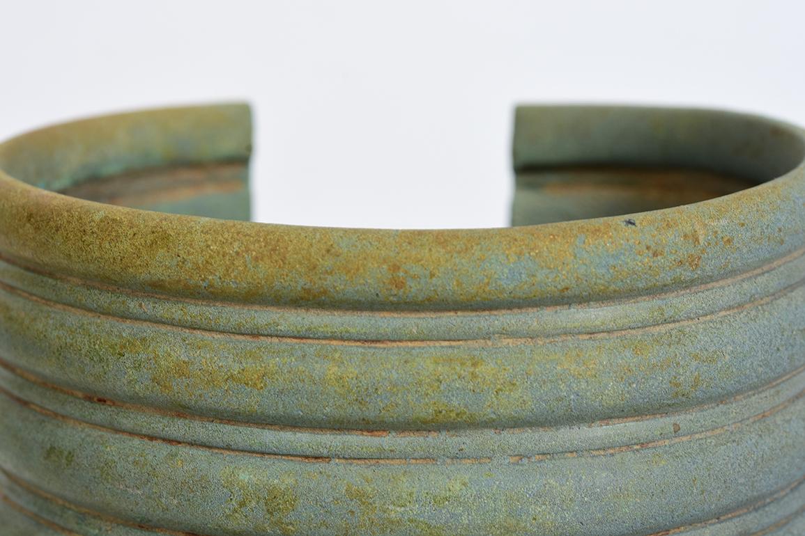 Dong Son bronze bangle with nice green patina.

Age: Cambodia, Dong Son Period, 500 B.C.
Size: Height 10.5 C.M. / Width 11.4 C.M.
Condition: Nice condition overall (some expected degradation due to its age).

100% satisfaction and authenticity