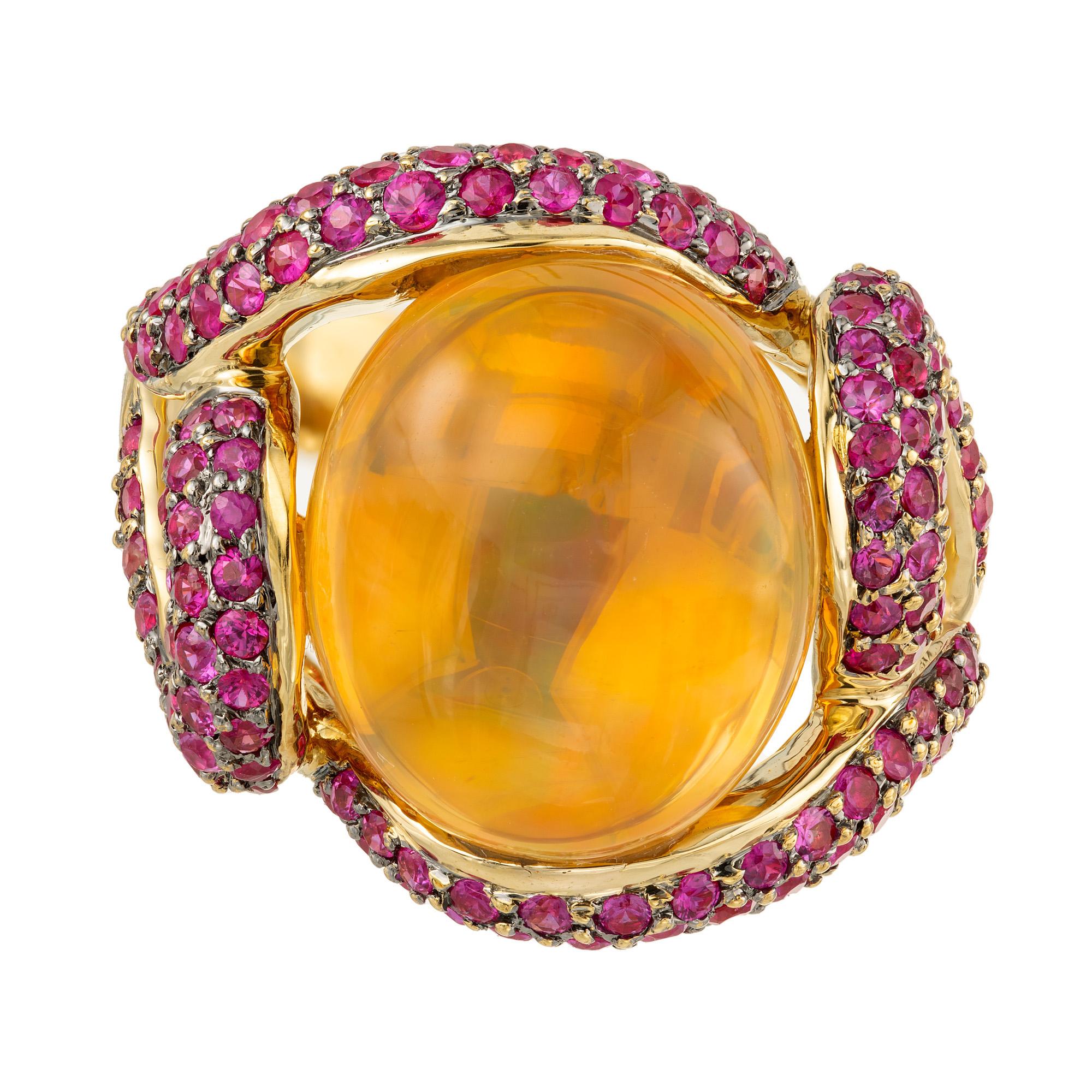 Designer Dyach Opal and ruby cocktail ring. 18k yellow gold free form swirl ring set with a natural Mexican fire Opal approx. 5.00cts. The opal has a stunning golden orange color with red, green, and blue flashes surrounded by pavé set bright red