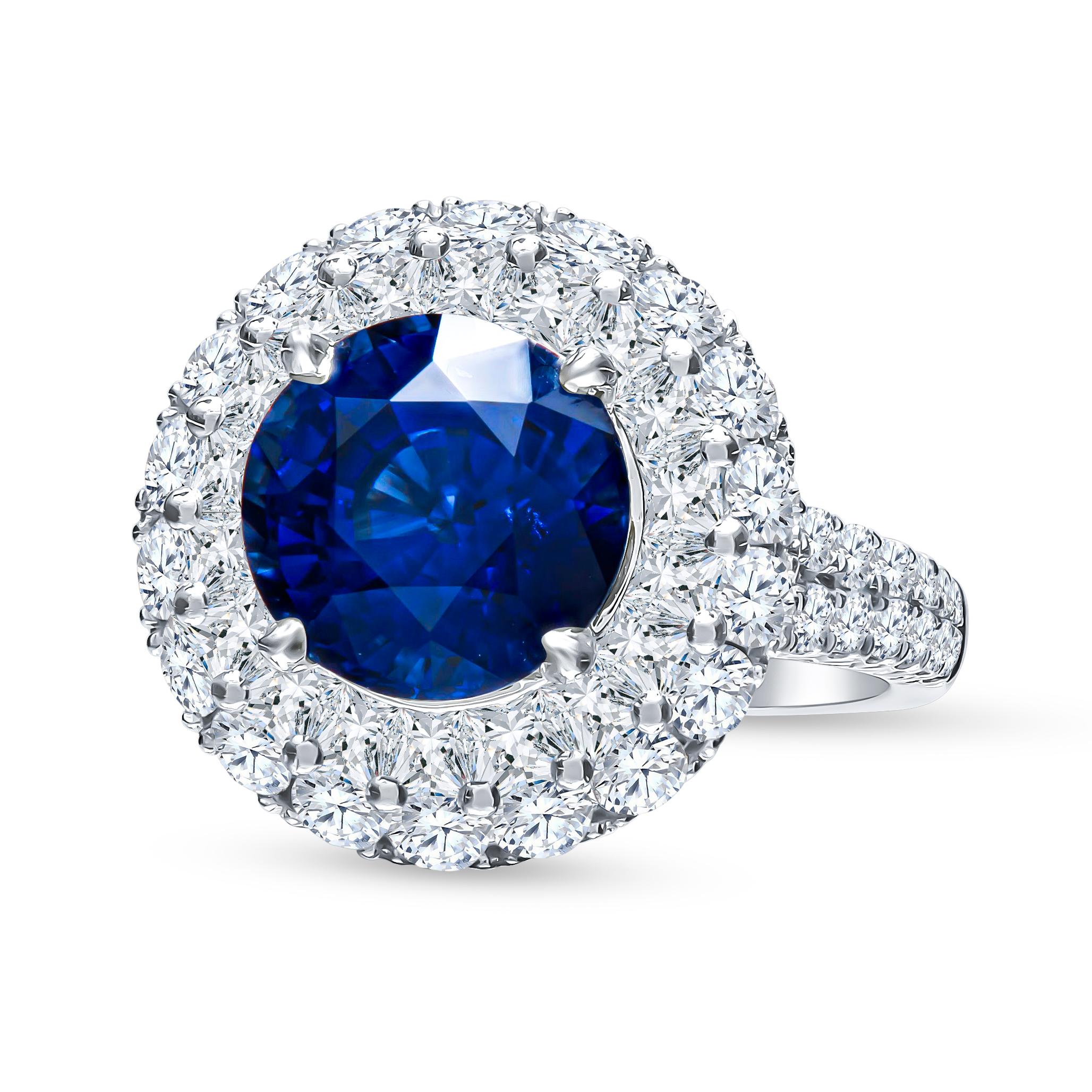 Absolutely beautiful in house crafted ring that showcases a 5 carat round royal blue sapphire that is surrounded by 2.63 carats total in round brilliant cut diamonds in double diamond halo as well as set in the split shank band. This piece makes a