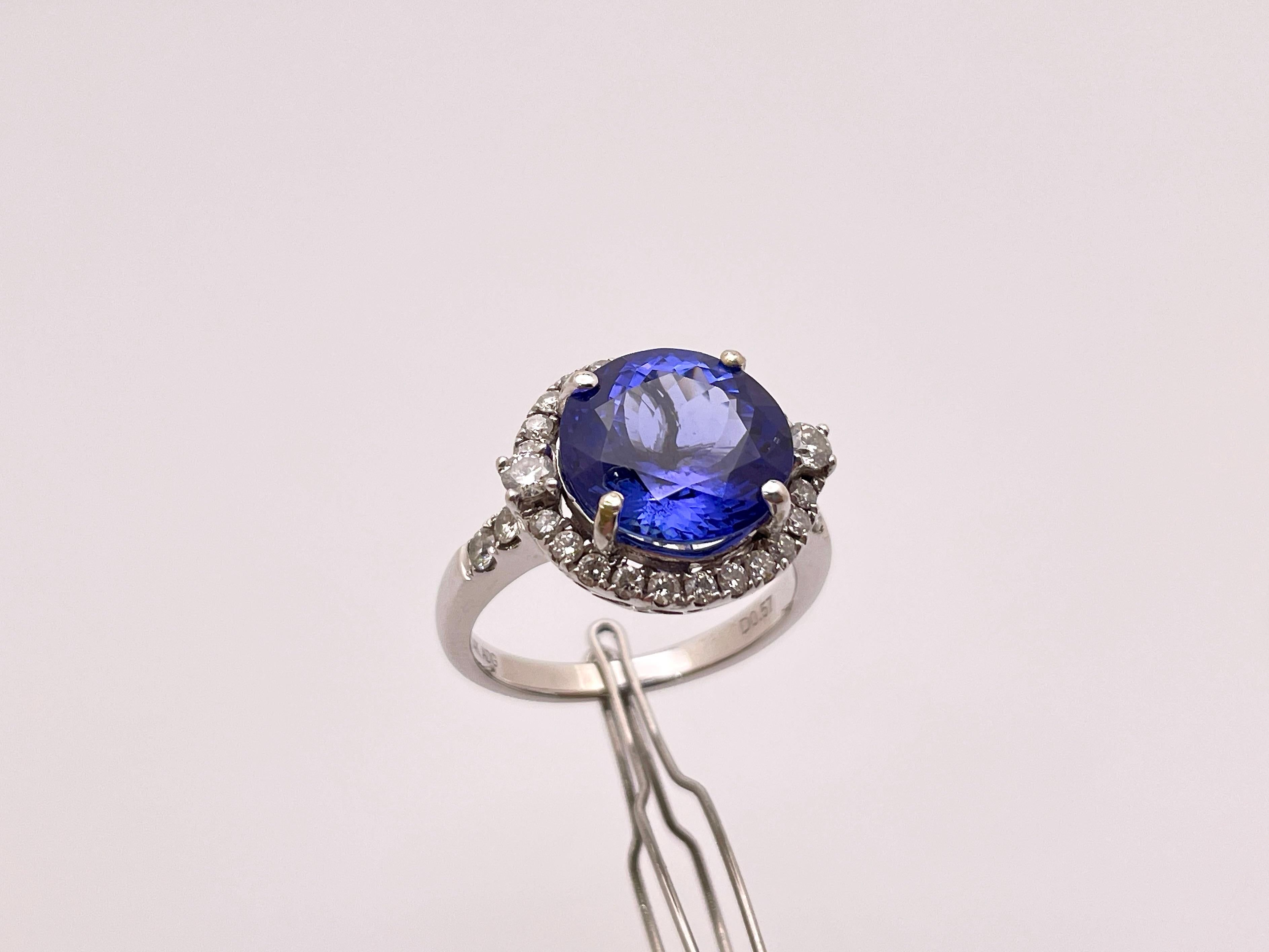 An original 14 K (karat) white gold tanzanite ring. Centered with one round brilliant cut natural tanzanite weighing approximately 5.00 CT (carats) and measuring 10.08 x 10.07 x 6.50 mm. Accented with 28 round brilliant cut diamonds weighing