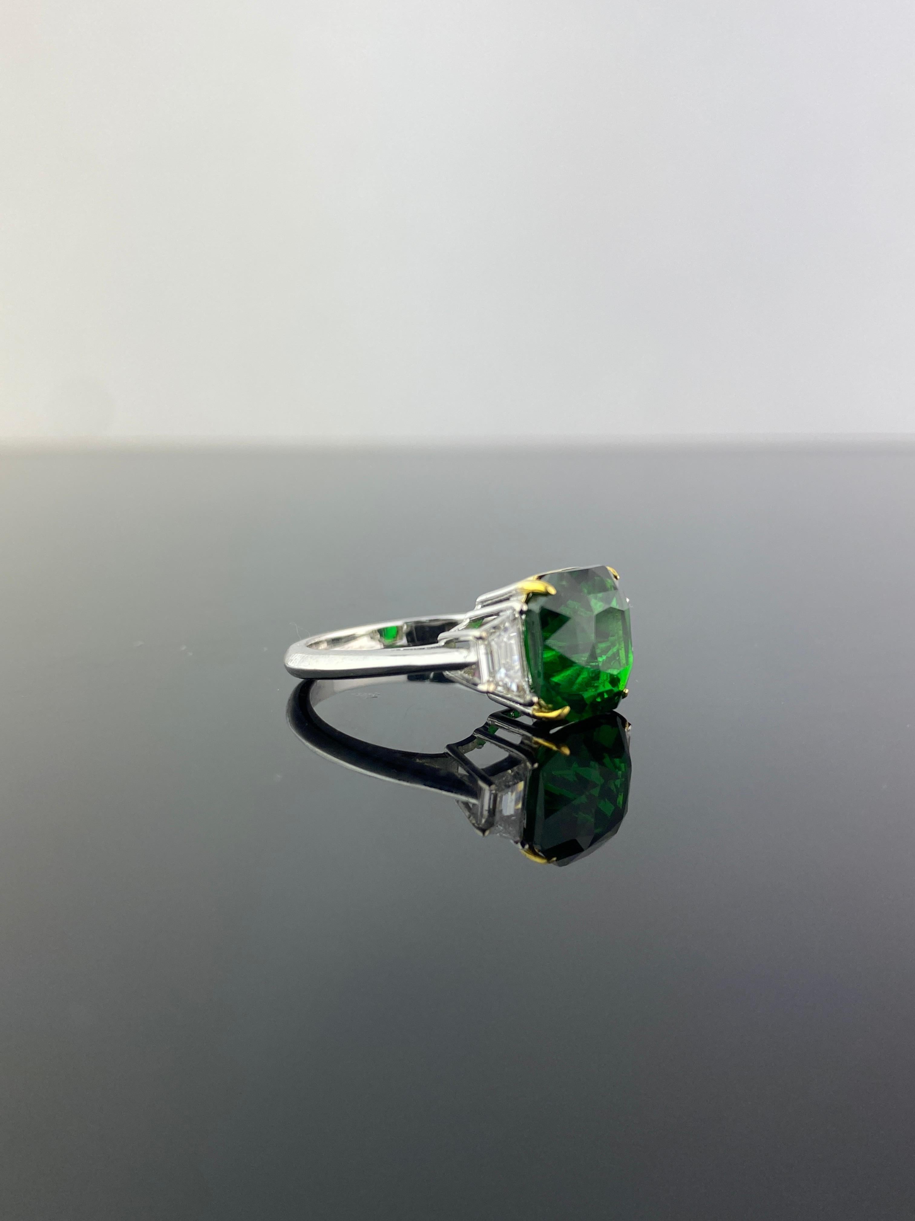 A beautiful, three-stone engagement ring with a 5.00 carat, octagon shape Tsavorite center stone - absolutely transparent, no inclusions, great cut and quality. This is The trapeze shaped White Diamonds are 0.44 carats in total, VS quality, G color.