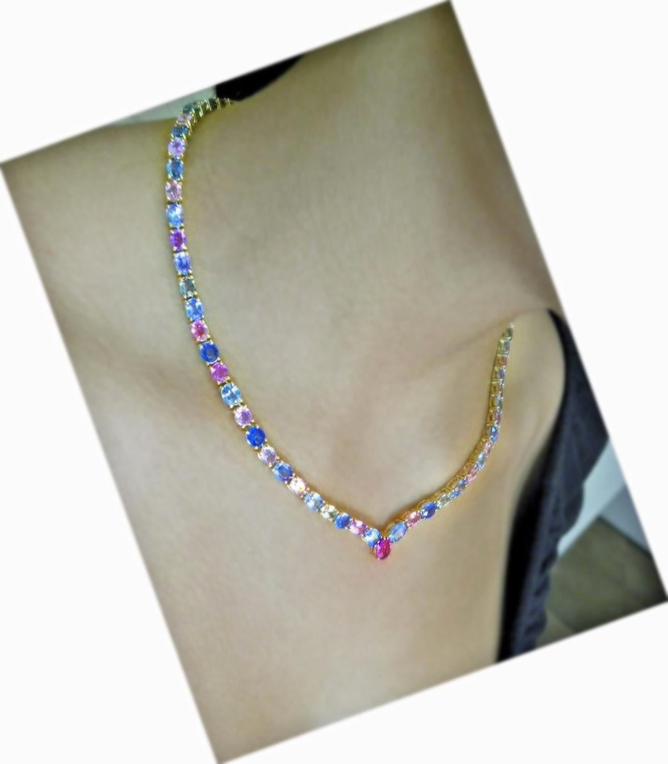 The stunning one-of-a-kind multicolor sapphire necklace features yellow, peach, green, pink, and blue oval cut Burmese natural sapphires   Ranging from medium-light to saturated in hue while weighing in a total of 50.00 carats, 18 karats yellow