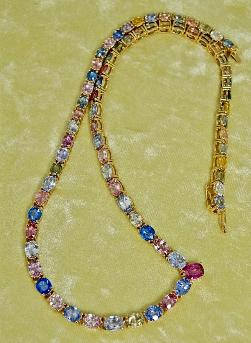 Superbe collier de saphirs birmans multicolores 100% naturels, unique en son genre, composé de saphirs birmans naturels de taille ovale jaunes, pêches, verts, roses et bleus.   D'un poids total de 50,00 carats, l'or jaune 18 carats présente des