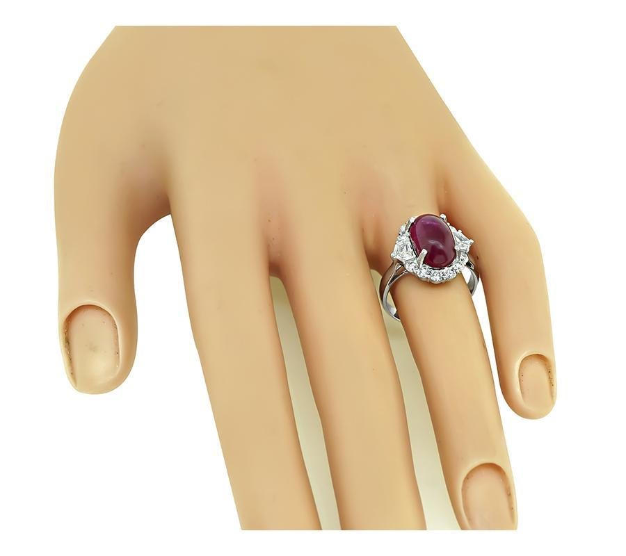 This is a charming 18k white gold ring. The ring is centered with a lovely cabochon Burma ruby that weighs approximately 5.00ct. The ruby is accentuated by sparkling round and shield cut diamonds that weigh approximately 1.10ct. The color of these