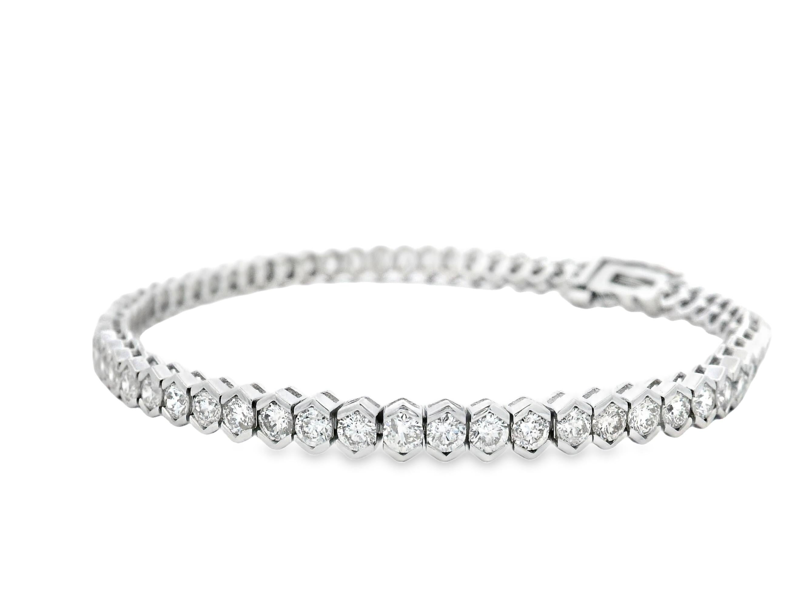 Questo sofisticato bracciale tennis presenta 62 diamanti tondi taglio brillante per un totale di ben 5,00 carati, incastonati in eleganti castoni esagonali realizzati in oro bianco 14K. Le incastonature a forma di esagono offrono un caratteristico