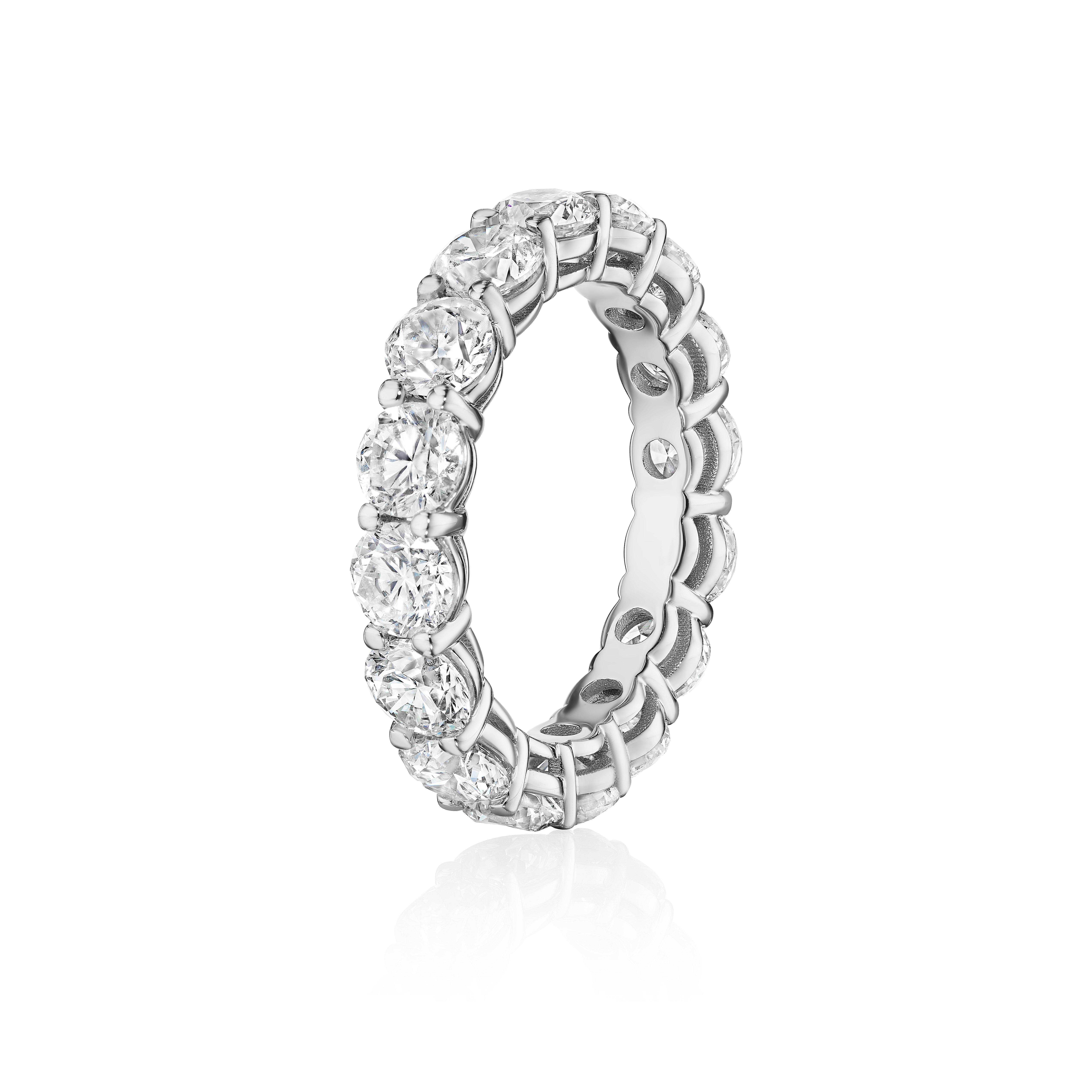 Crafted in 18KT gold, this eternity band is made with 16 round brilliant cut diamonds which encircle the finger. The band has a combining total weight of approximately 5.00 carats. The diamonds are set in a shared prong setting. Worn beautifully on