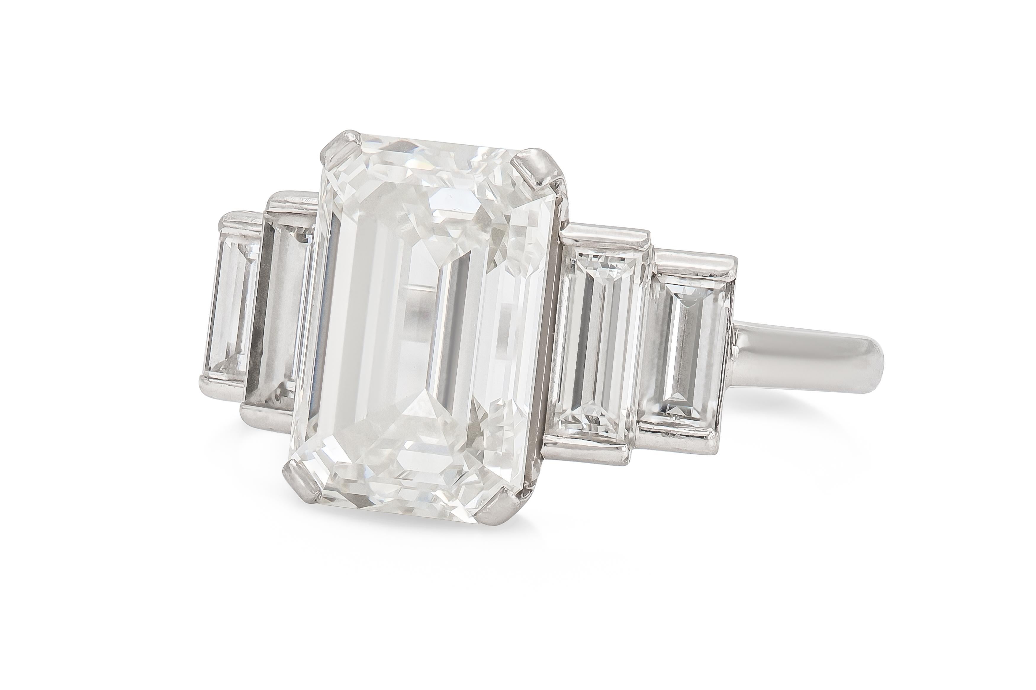Finamente elaborado en platino con un Diamante talla Esmeralda certificado por el GIA de 5,01 quilates, color H, claridad VS1, GIA #2205568491.
El anillo tiene 4 diamantes talla baguette.
Tamaño 5, redimensionable