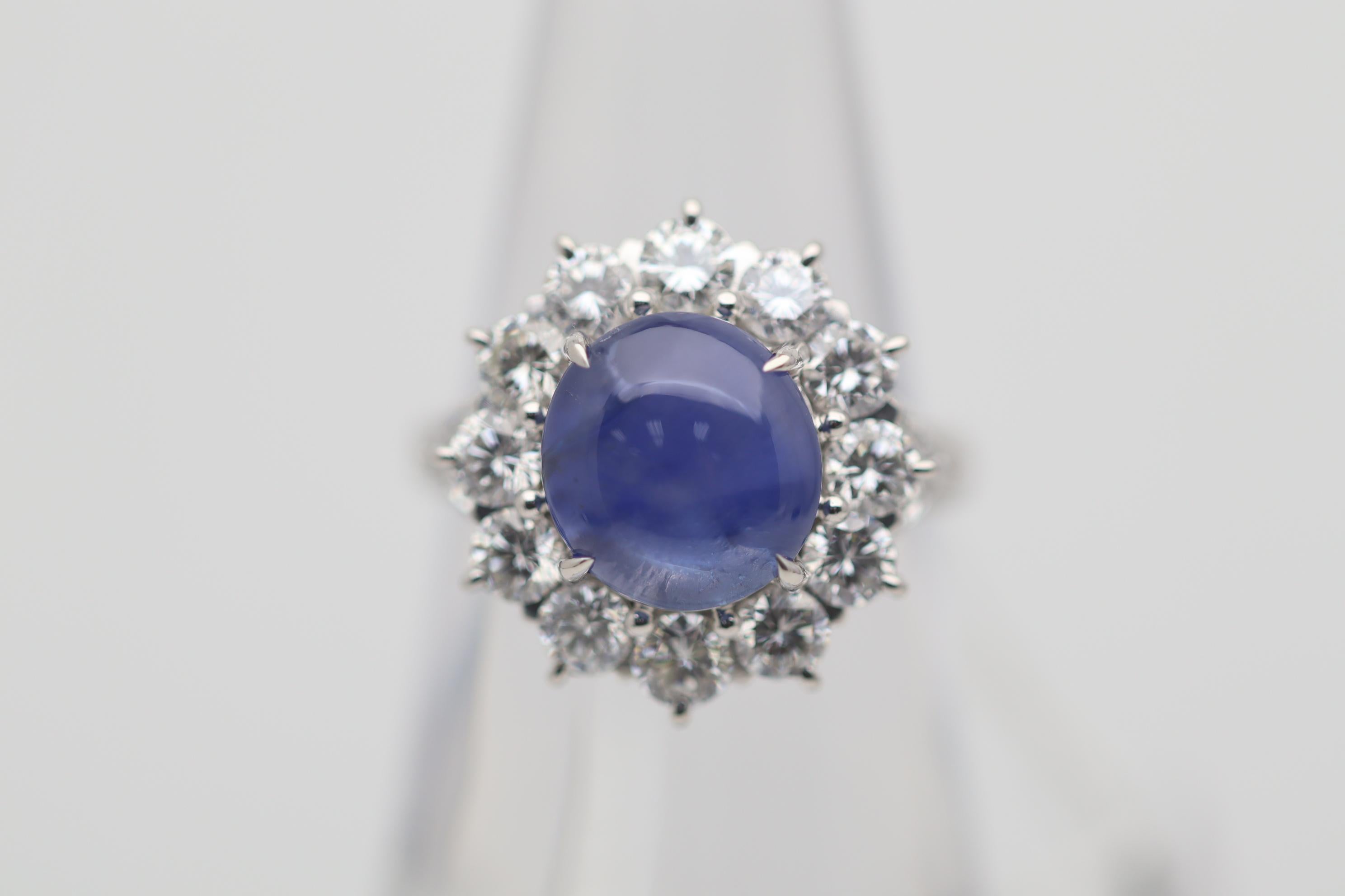 A very fine example of a blue star sapphire. It weighs 5.01 carats and has the most amazing gem blue color. Adding to that, it has a strong 6-rayed star when a light hits its stop adding to its beauty. Haloing the sapphire are 1.78 carats of large