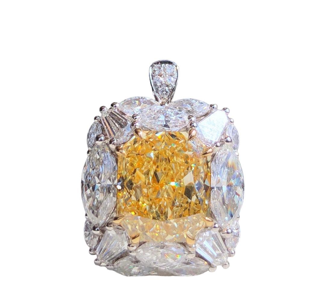 Wir laden Sie ein, diesen majestätischen Ring mit einem GIA-zertifizierten Fancy Yellow-Diamanten im Kissenschliff von 5,01 Karat zu entdecken, der durch farblose Diamanten im Marquise- und Baguetteschliff von insgesamt 3 Karat ergänzt wird. Die