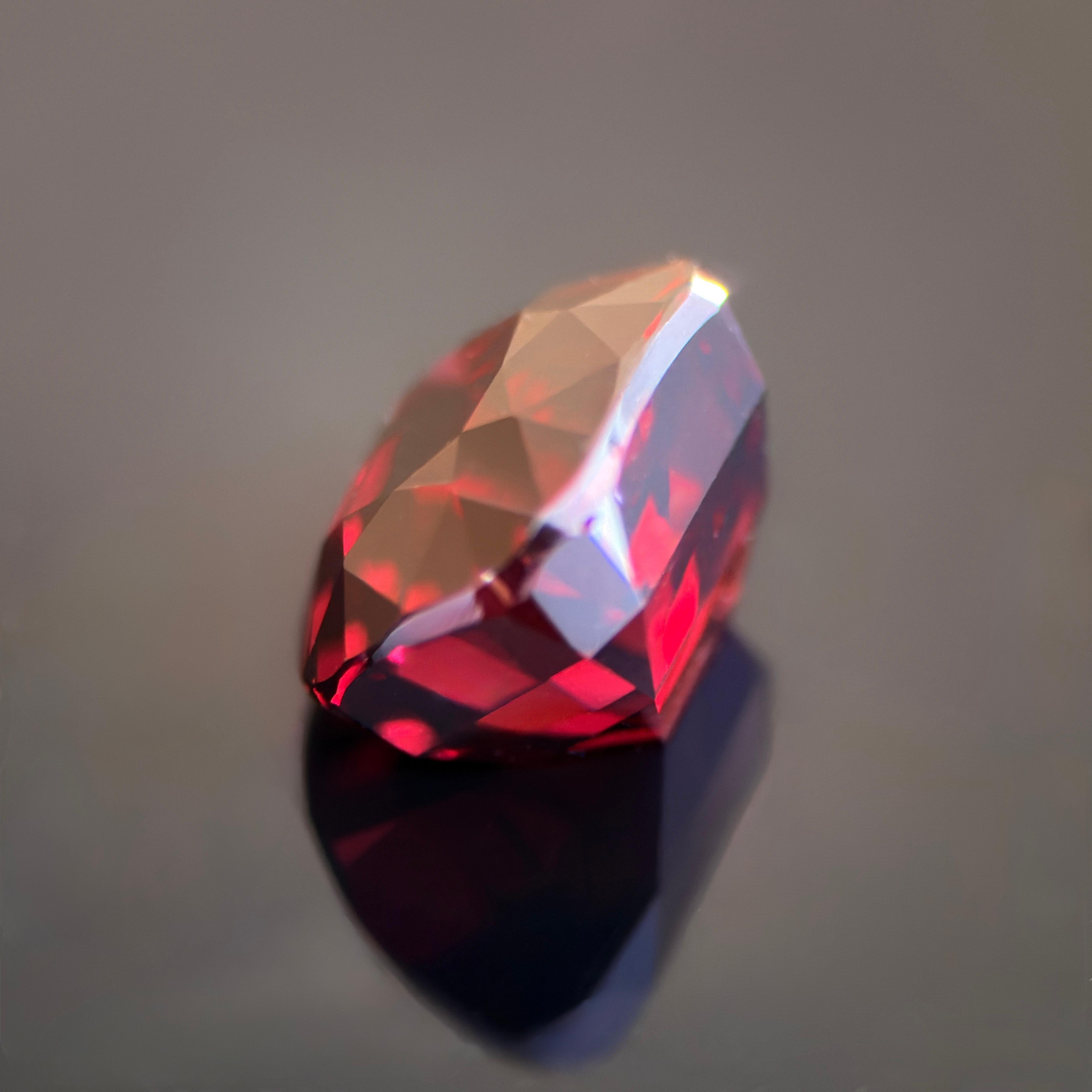 Ce grenat naturel de 5,01 carats incarne l'élégance intemporelle avec son ton rouge profond et velouté et son feu interne remarquable. Facettée de manière experte en une taille coussin raffinée, la pierre capte et reflète la lumière avec une
