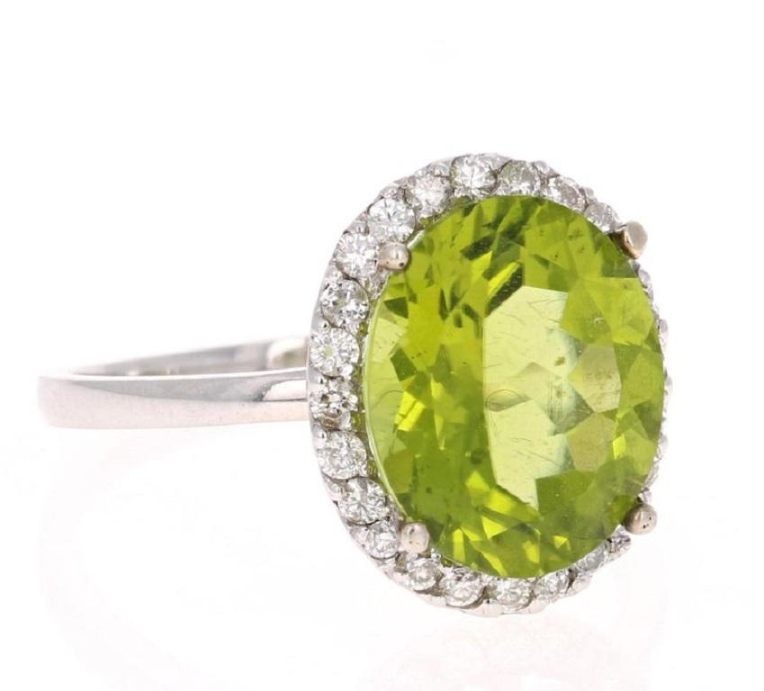 This beautiful ring has an Oval Cut Peridot in the center that weighs 4.66 carats. The ring is surrounded by a Halo of 24 Round Cut Diamonds that weigh 0.35 carats. The total carat weight of the ring is 5.01 carats. 
The setting is crafted in 14K