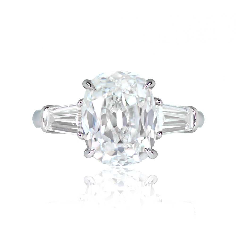 This exquisite solitaire engagement ring showcases a vibrant 5.01-carat antique cushion-cut diamond with E color and VS2 clarity. The central gem is elegantly secured with prongs and is complemented by tapered baguette-cut diamonds on the shoulders,