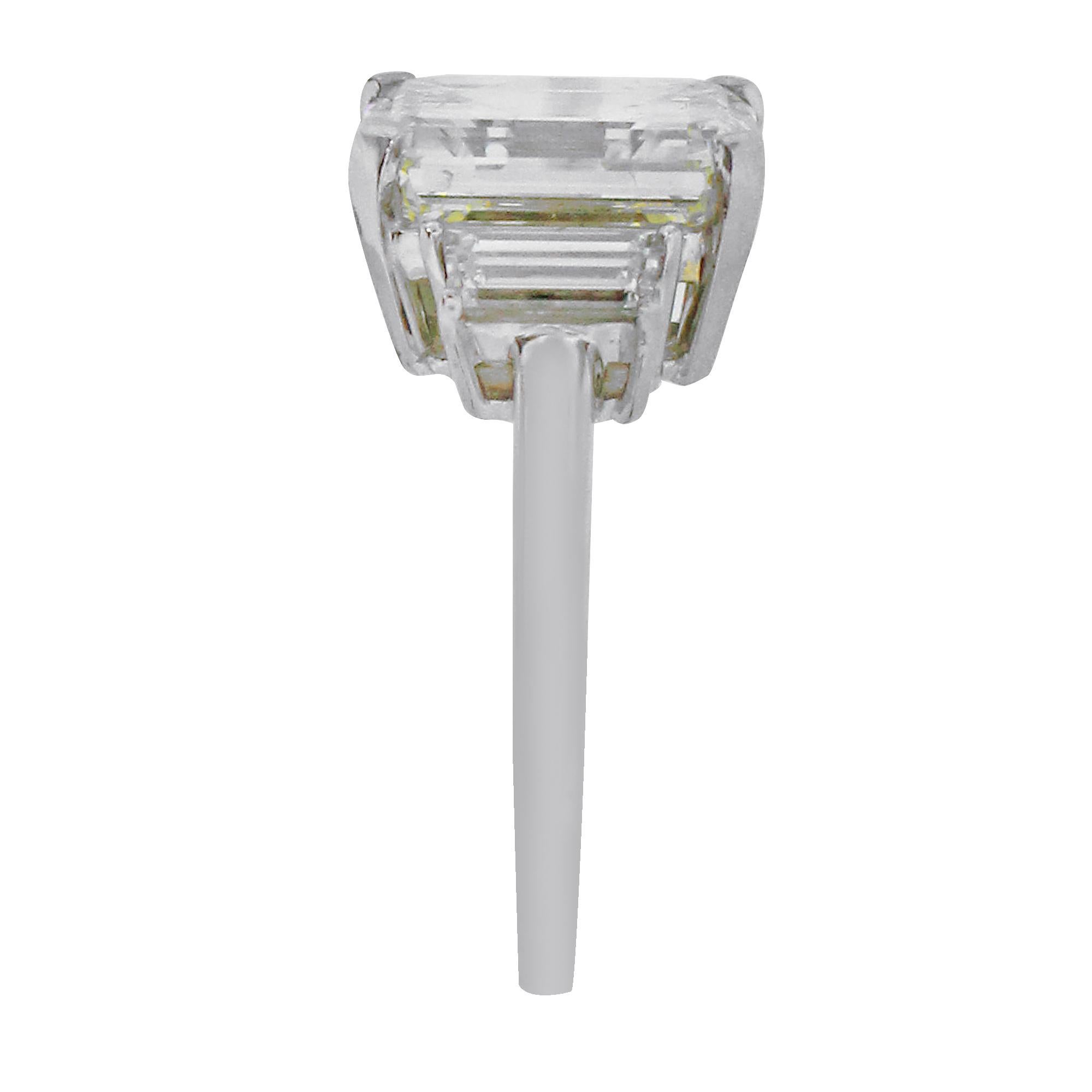 Material: Platinum
Center Diamond Details: 5.01ct Emerald Cut Diamond. Center diamond is M in color and SI2 in clarity.
Accent Diamond Details: Approximately 0.36ctw trapezoid diamonds. Accent diamonds are G in color and SI in clarity.
Ring Size: