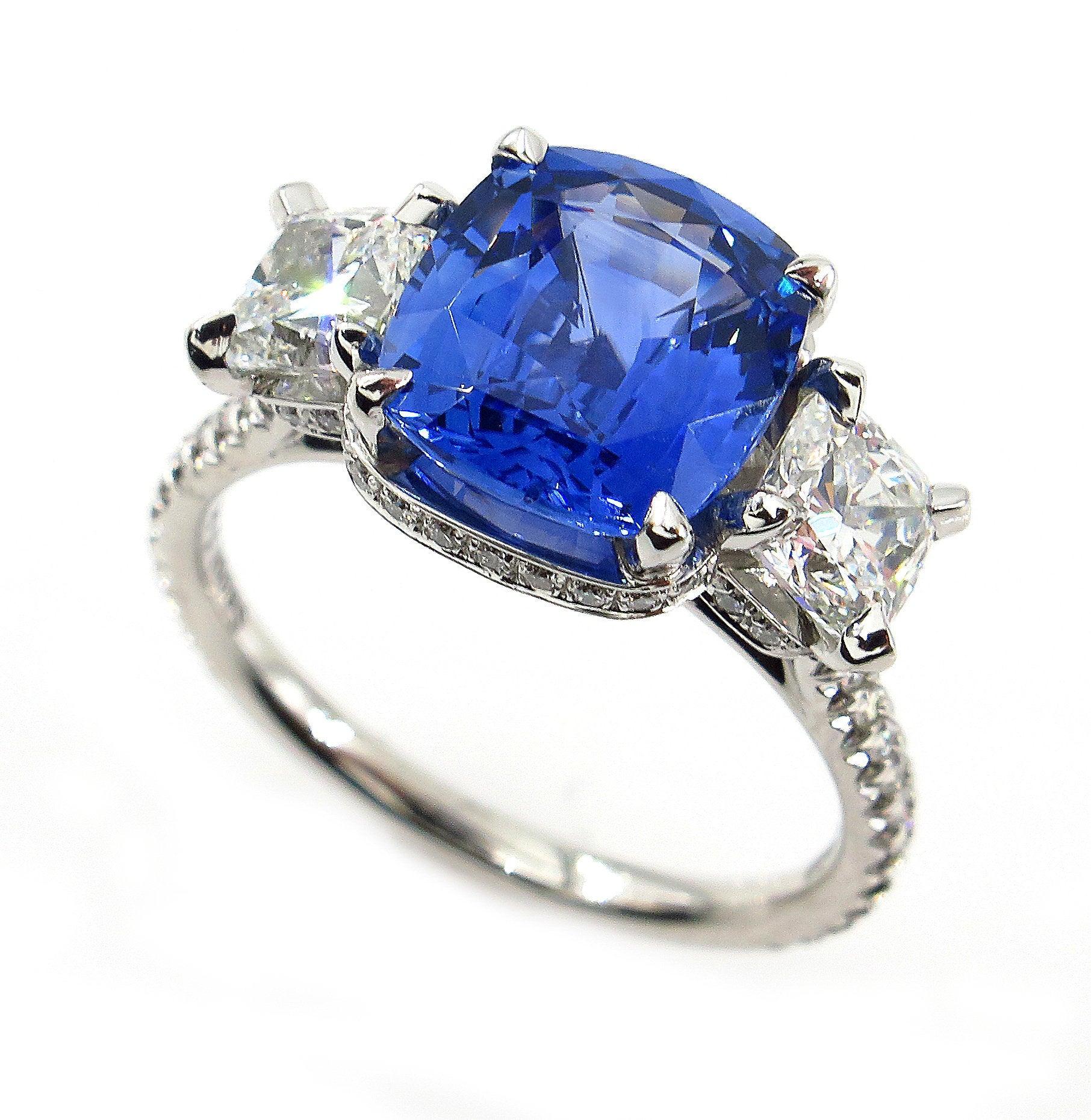 An Iconic Style and VERY ELEGANT Ceylon Natural Gorgeous Deep Blue Sapphire & Diamond Trilogy Ring.
A SUPER fine Estate Ring features a Gorgeous gem : 3.36 carat Natural CEYLON Cushion Cut Deep Blue Sapphire Measuring 9.24x8.25x4.76mm, bearing a