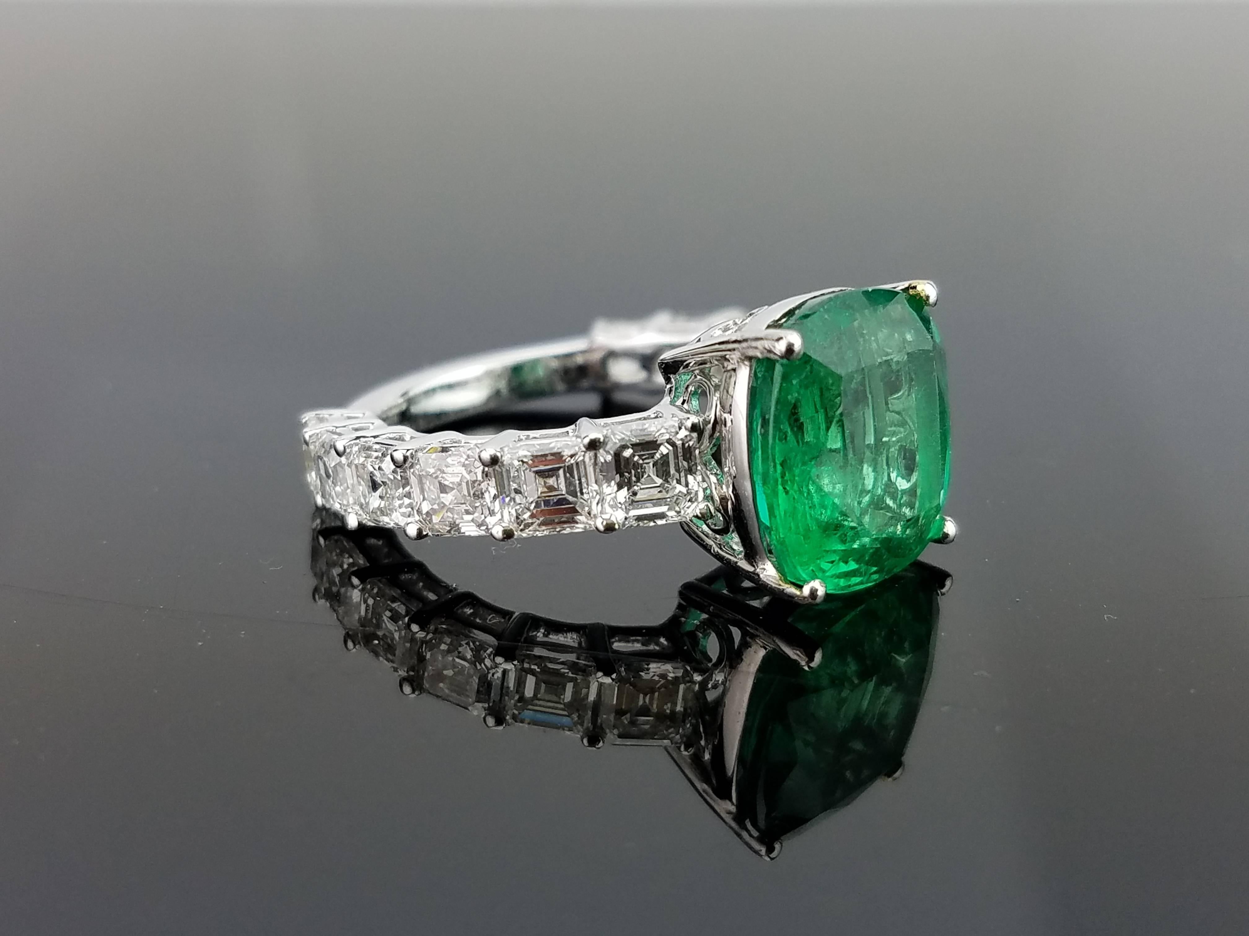 An elegant and simple cocktail ring using a 5.02 cushion cut Zambian Emerald centre stone, with a 1.5 carat diamond band all set in 18K white and gold. 

Stone Details: 
Stone: Zambian Emerald
Carat Weight: 5.02 Carats

Diamond Details: 
Total Carat