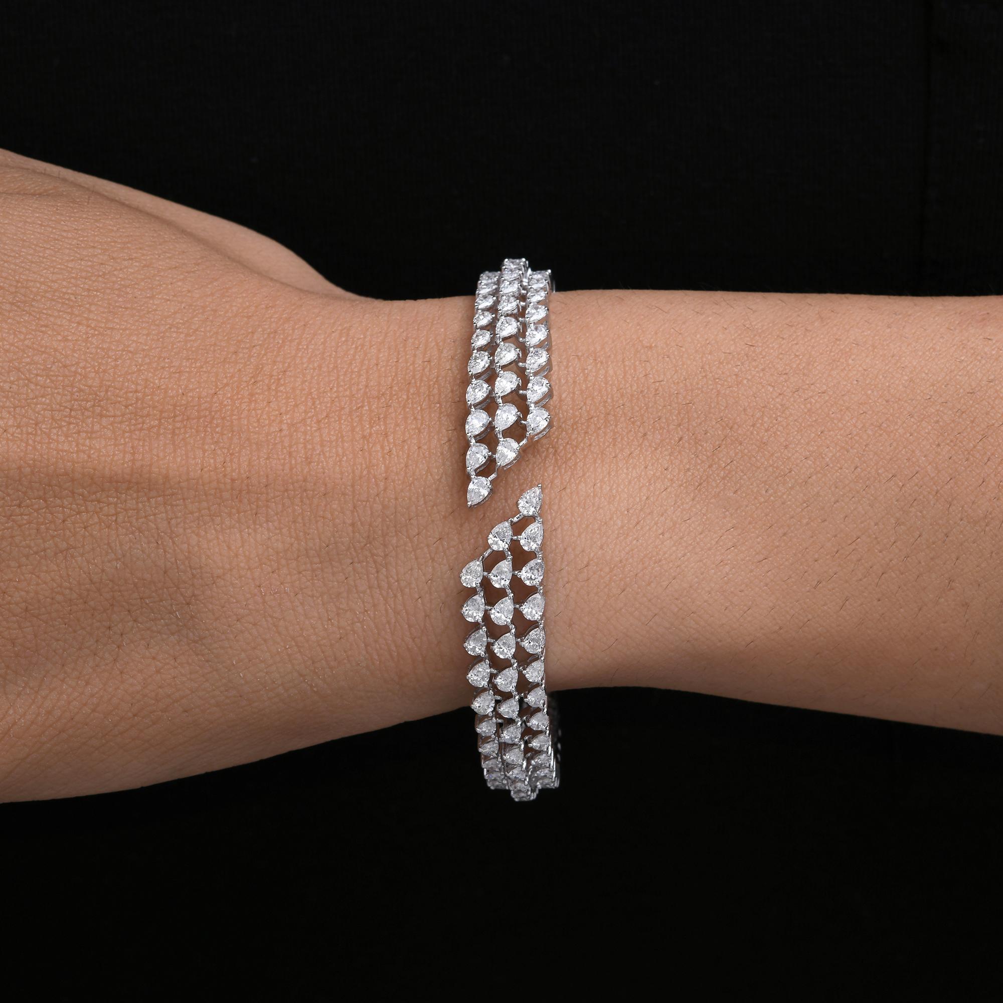 Dieses Manschettenarmband aus 14 Karat Weißgold mit 5,02 Karat SI/H-Diamanten und breiter Verlobung zeichnet sich durch Diamanten im Birnenschliff aus, die in drei Reihen angeordnet sind und ein offenes Manschettenarmband bilden.
Diamanten sind ein