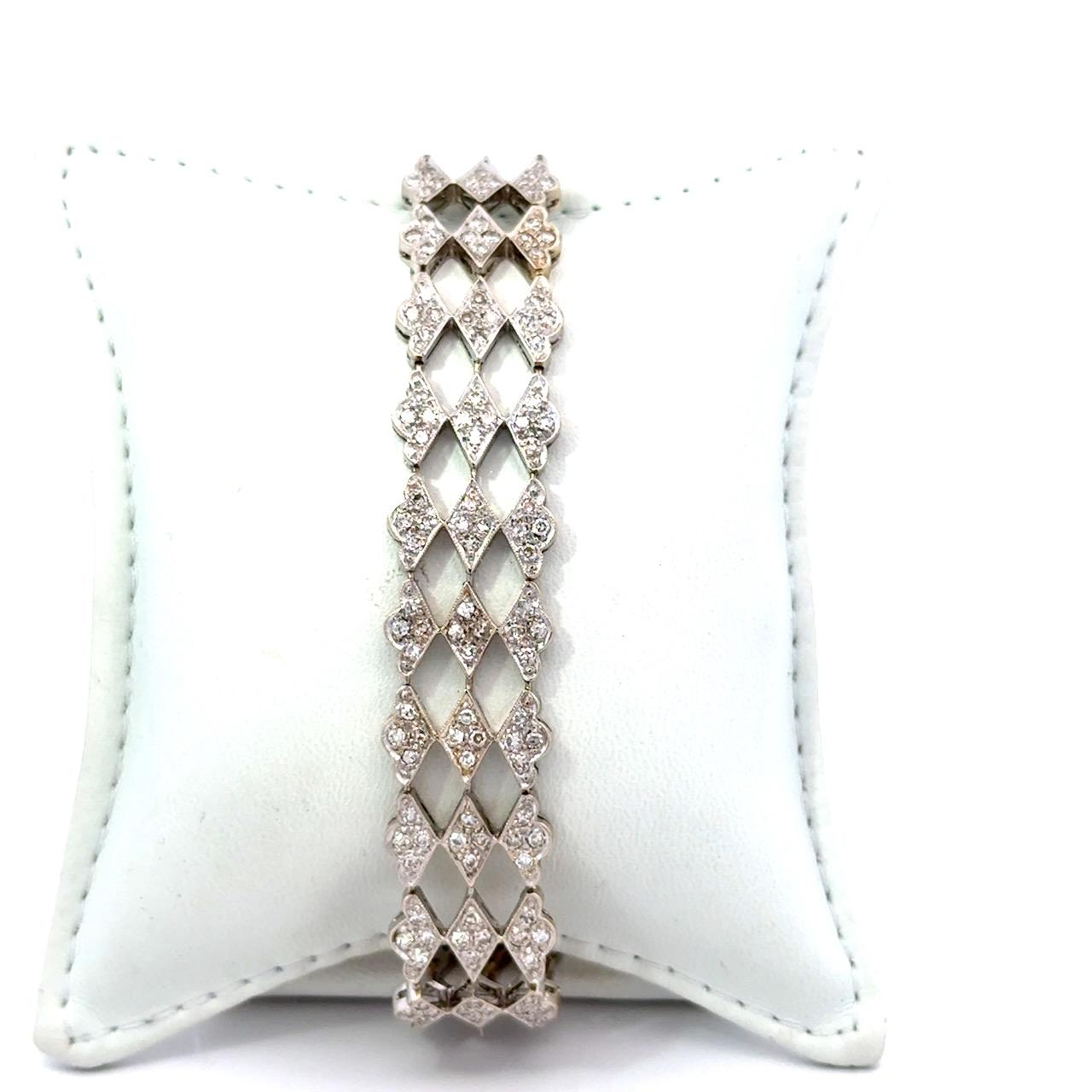 This Vintage Diamond Statement Bracelet with a Diamond Shaped Pattern Dates from The 1940’s.
5.02CT Sparkly Round Diamonds
H-J Color  SI-I Clarity
It is Crafted in 18kt White Gold 
7” Long and 14.3mm Wide
The Clasp Features a Safety Bar.
It Weighs