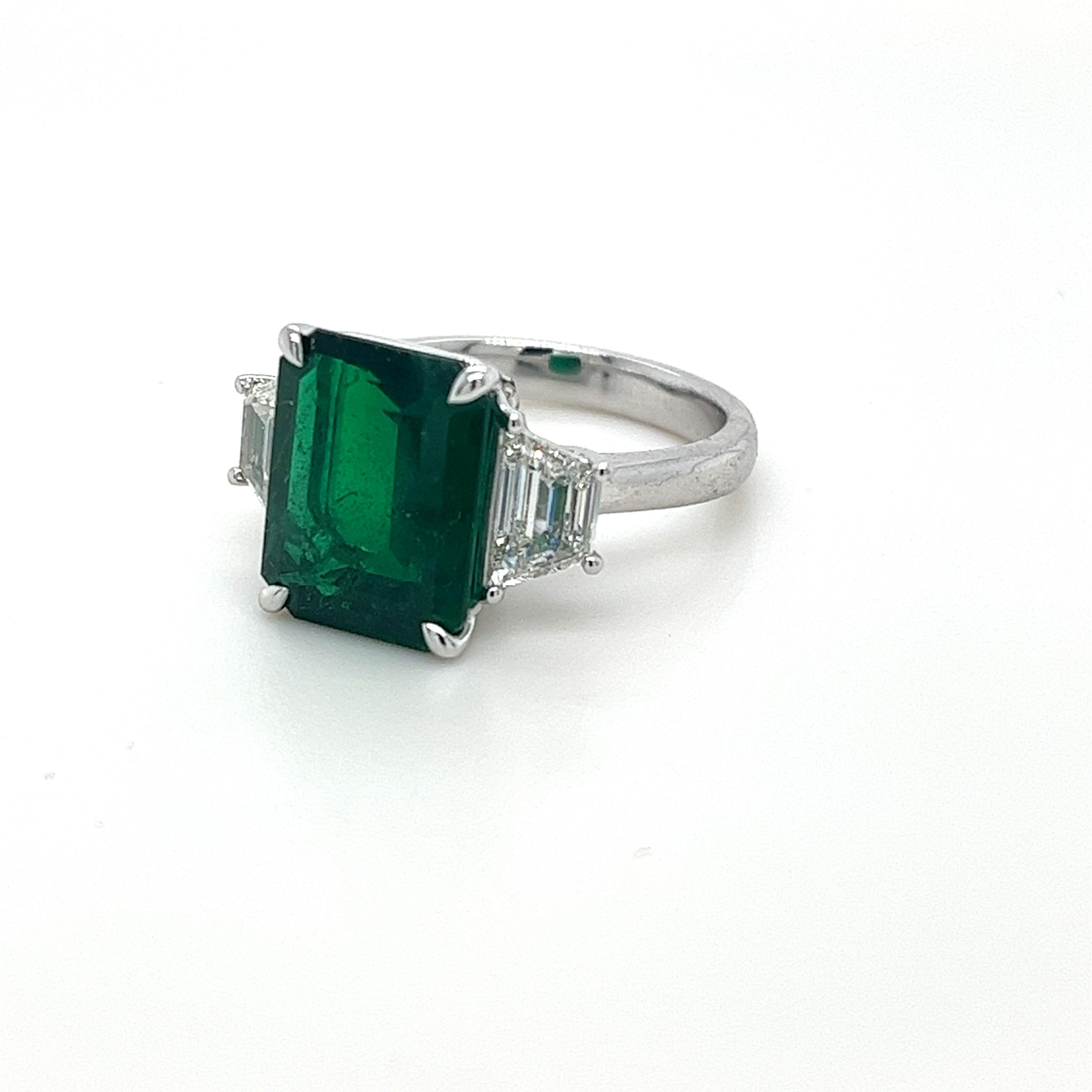 Emerald Cut Emerald weighing 5.03 carats
Measuring (12.5x9.9) mm
Trapezoid Diamonds weighing 1.02 cts
Diamonds are G-VS1
Set in platinum ring
8.30 grams
Emerald has rich green color