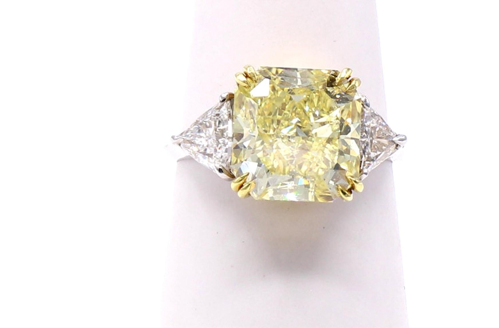 A gorgeous Natural Fancy Intense Yellow radiant cut diamond weighing 5.03 carats is the center piece of this lovely engagement ring. Accompanied by a report from the GIA giving this diamond a clarity grade of VS2 and an even color distribution, the