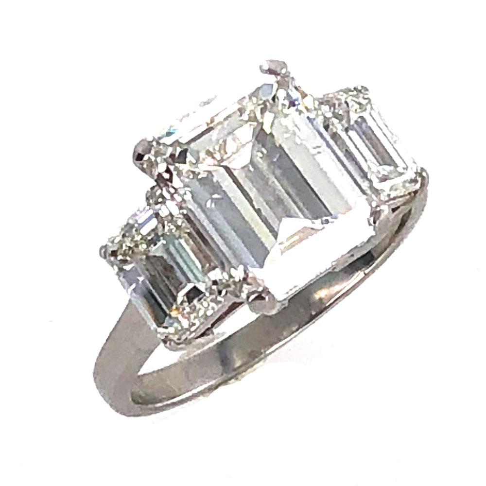 This elegant engagement ring features a 5.03 carat emerald cut diamond graded H color and VS2 clarity. The center diamond is flanked by two emerald cut diamonds. One is 1.13 carat I/VVS2, and the other is 1.03 carat I/VVS2. All set in platinum, the