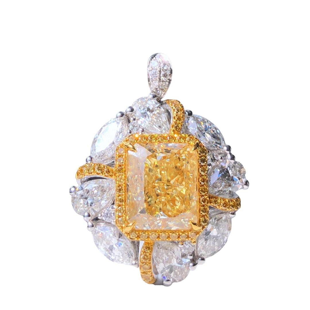 We invite you to discover this majestic ring set with a rectangular (radiant) Fancy Light Yellow cut diamond of 5.04 carat GIA certified enhanced with a halo of yellow diamonds and colorless pear and marquise cut side diamonds weighing 2.99 carats